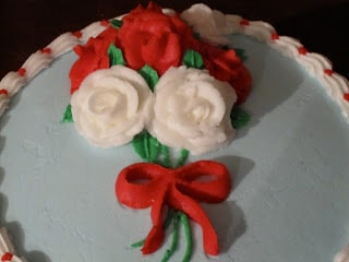 A close up of roses on a birthday cake