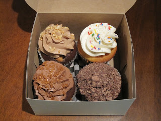 A box filled with different types of cupcakes.