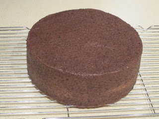 Crumb coated cake on a cooling rack.