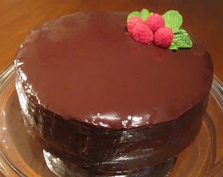 Cake covered in ganache with berries to decorate.