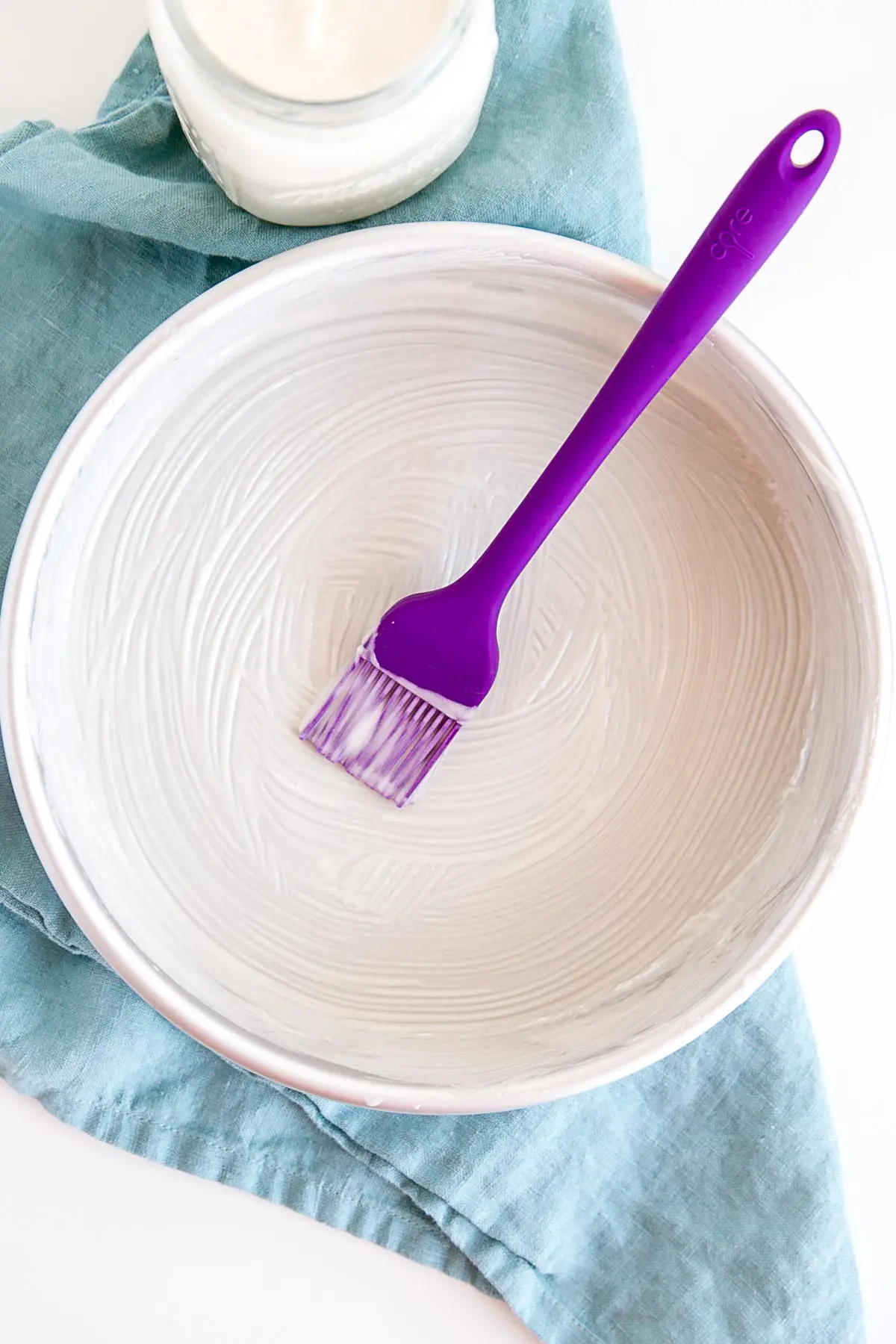 Cake pan prepped with cake release with pastry brush in it.