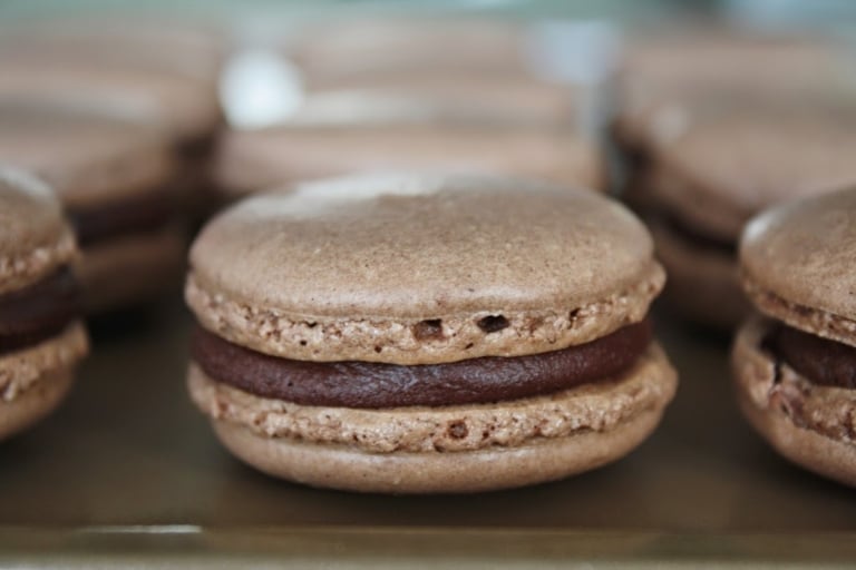 A close up of a chocolate macaron