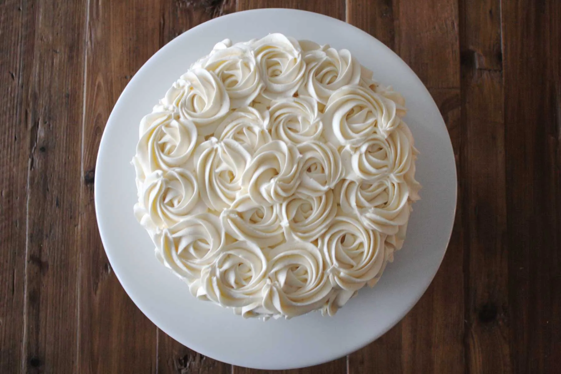 Aufsicht auf Buttercreme-Rosetten auf einem Kuchen.