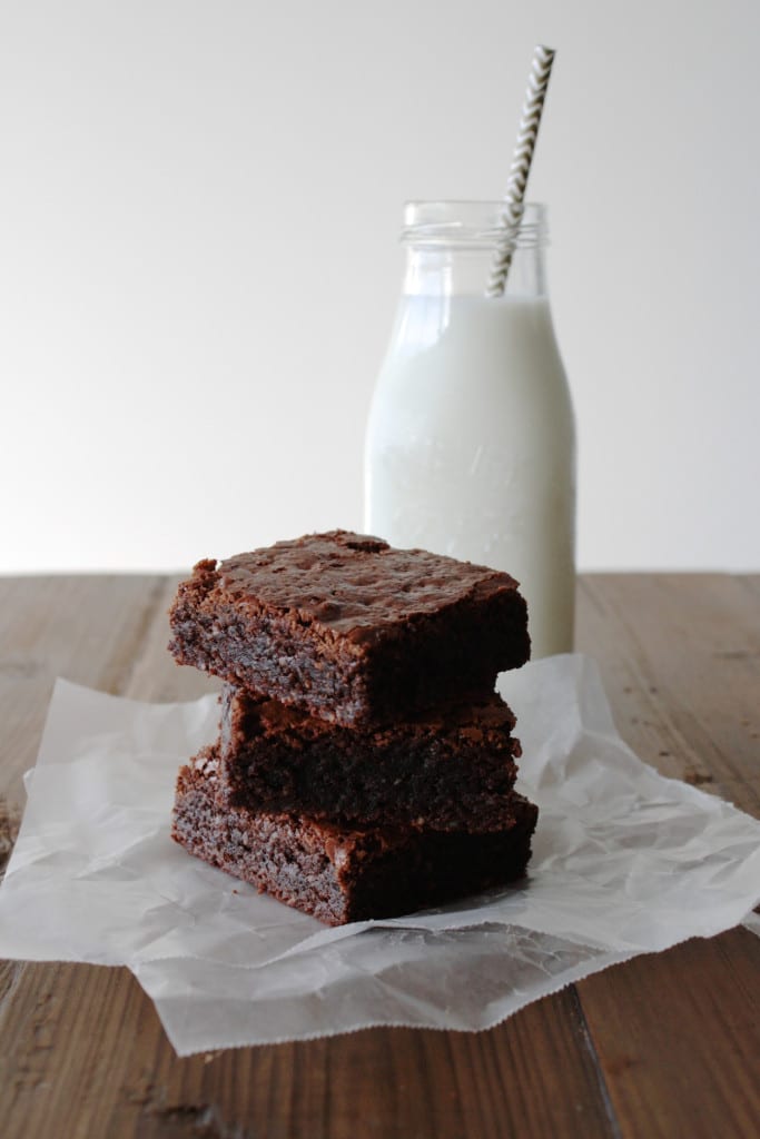 Stack of brownies with a glass of milk.