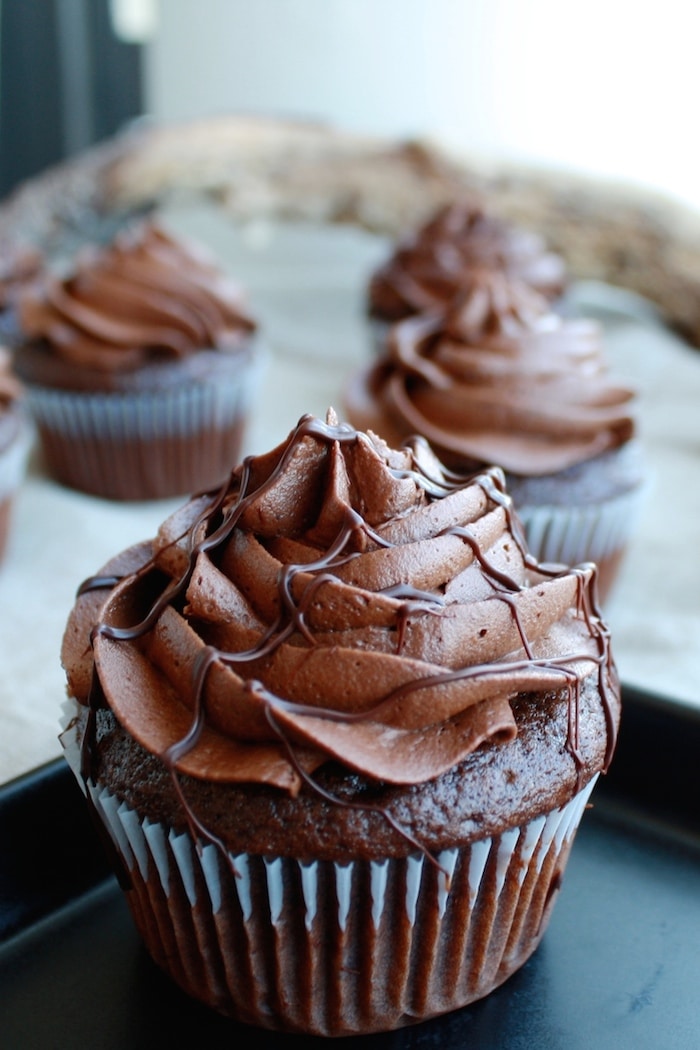 A close up of a chocolate cupcake on a plate