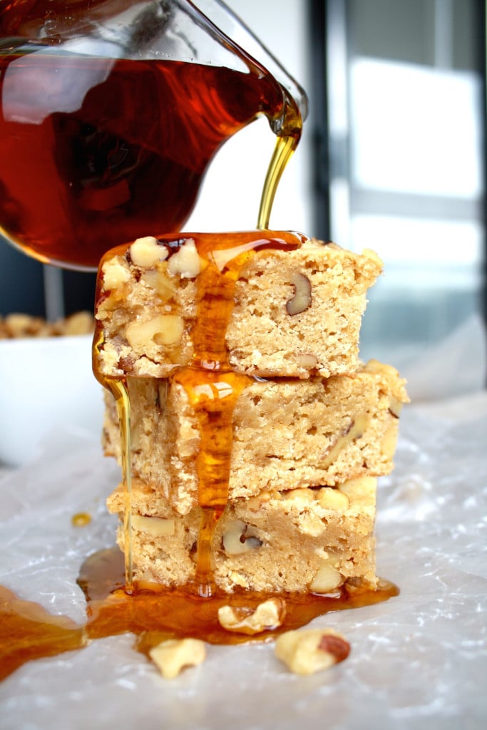 Stack of maple bars with maple syrup being drizzled on top.