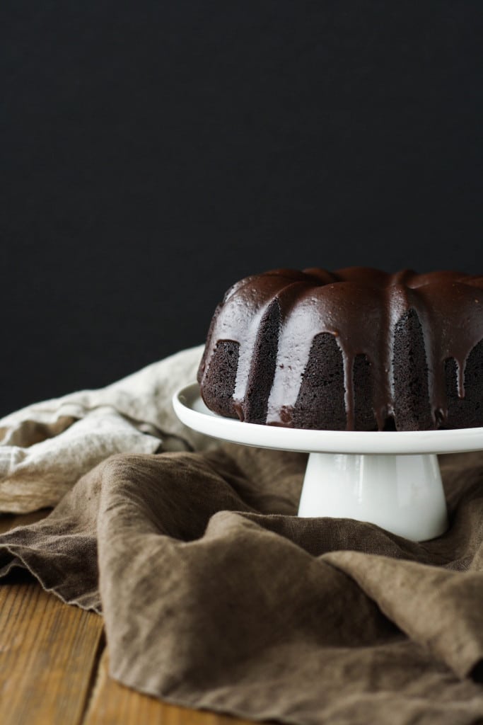 Chocolate Bundt cake on a white cake stand.