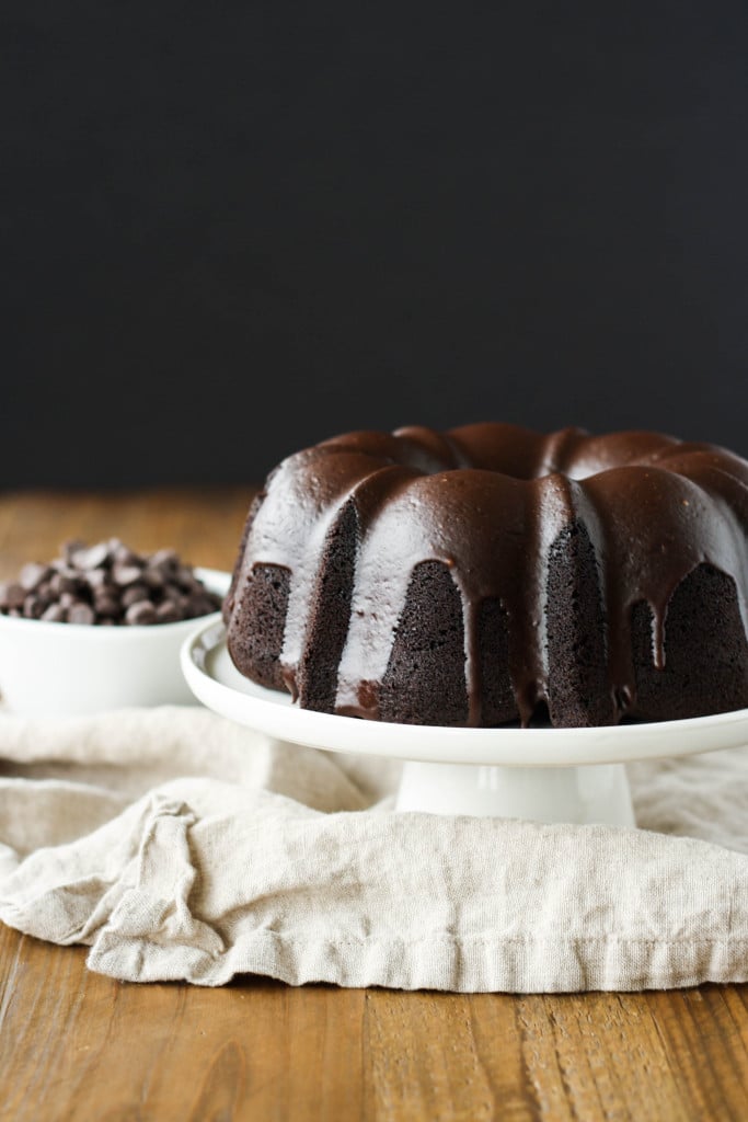 Chocolate Bundt cake on a white cake stand.