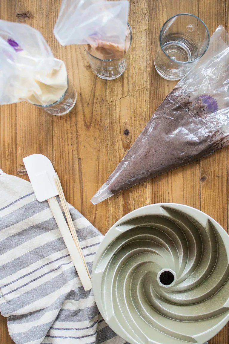 Dark cake batter in a piping bag.