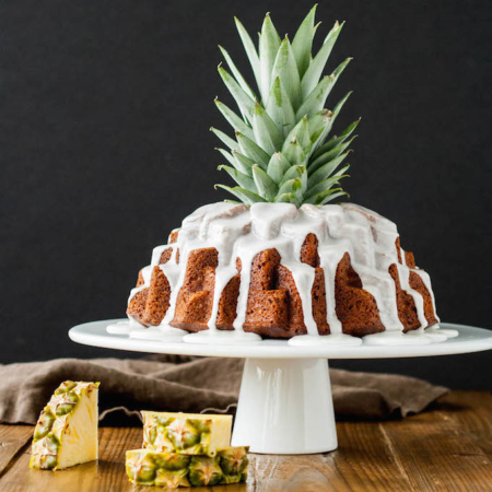 Tropical bundt cake with a pineapple stalk sticking out of the middle.