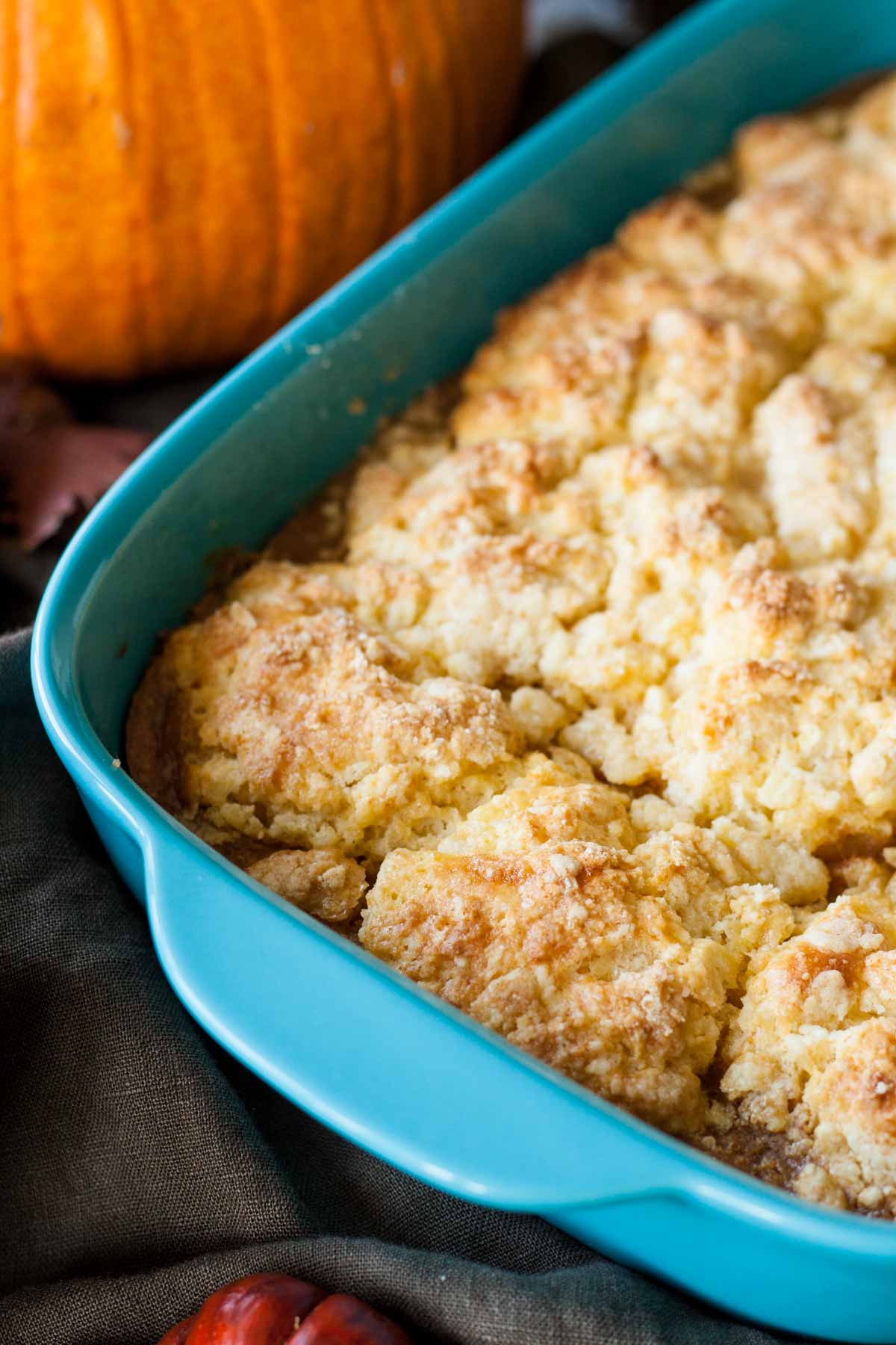 Close up of the pumpkin cobbler in the teal casserole dish.