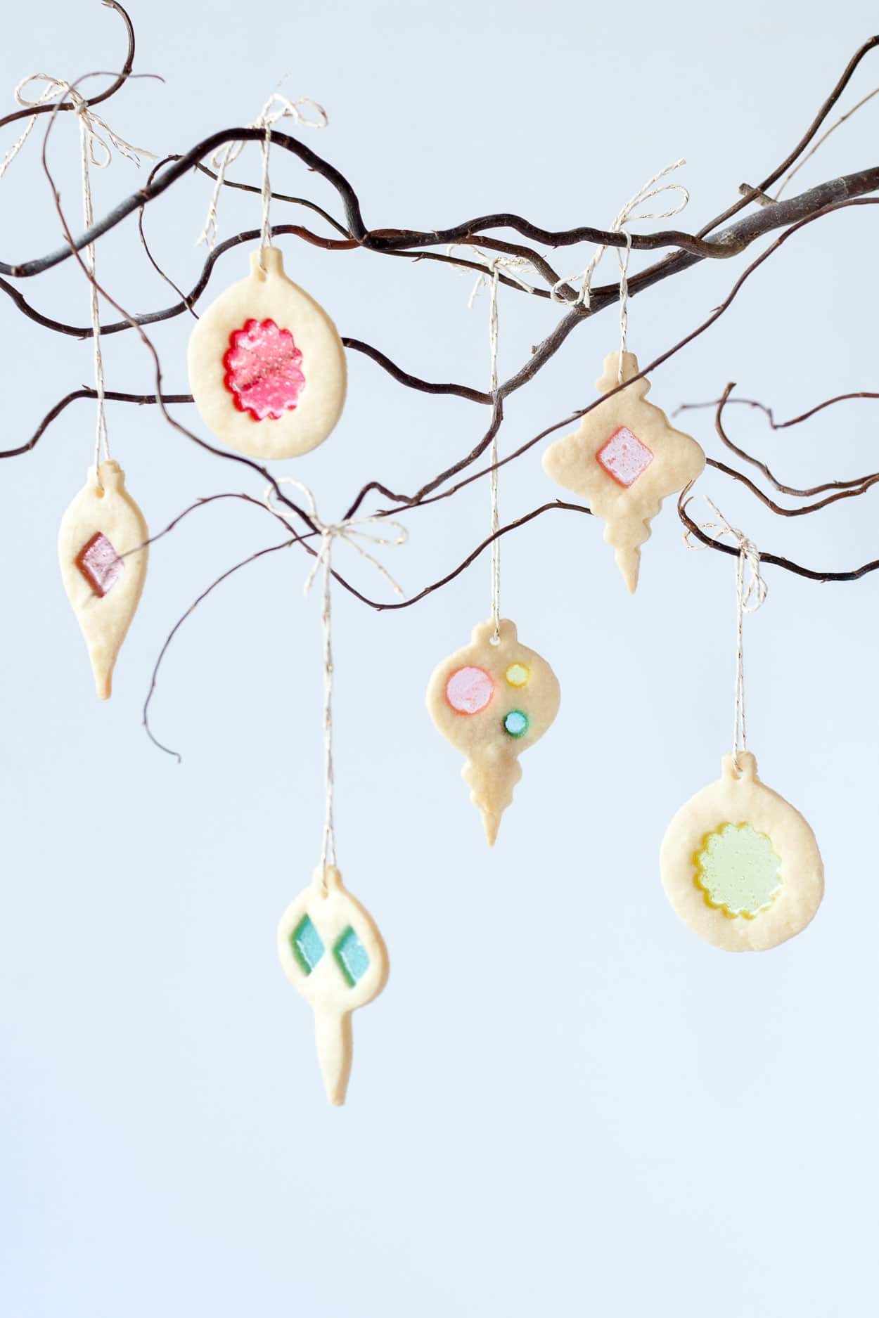 Stained glass cookies hanging from a branch.