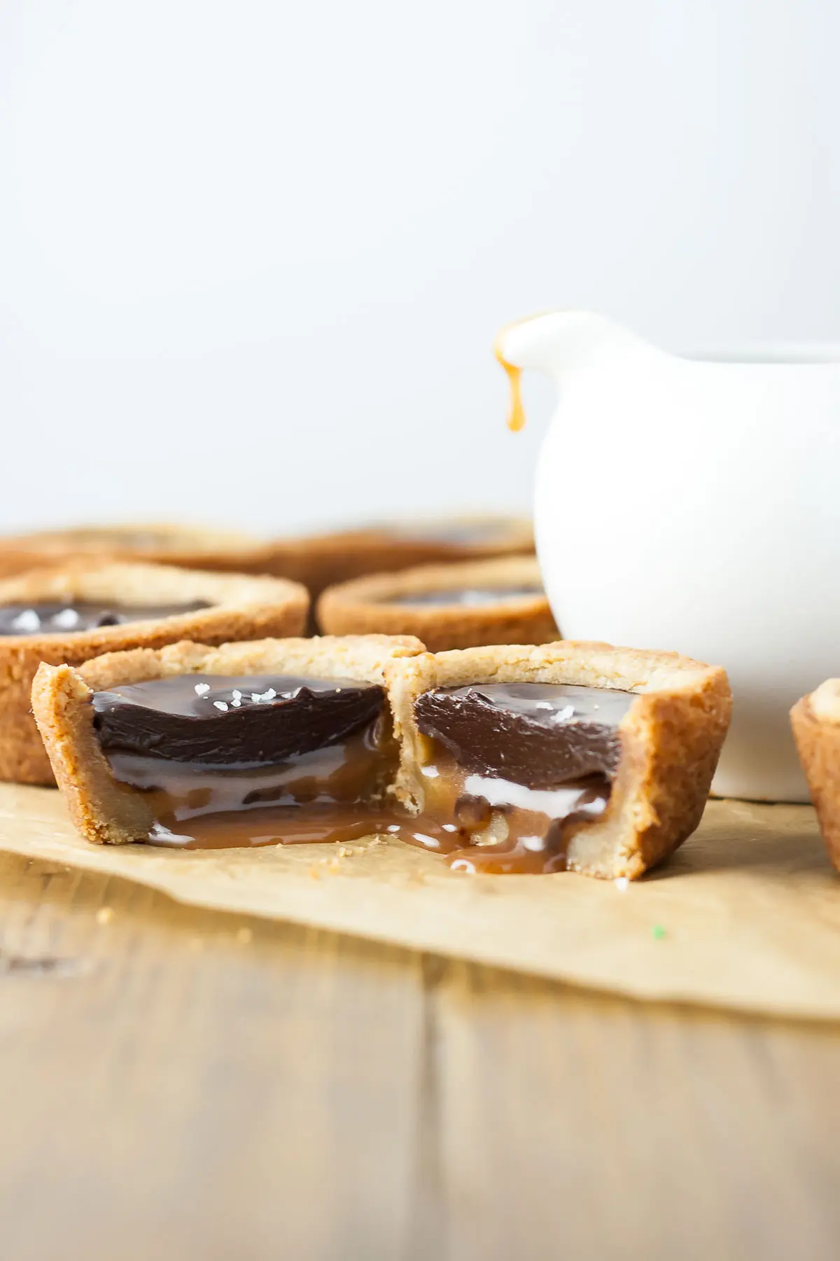 Two cookie cup halves beside each other with caramel oozing out.