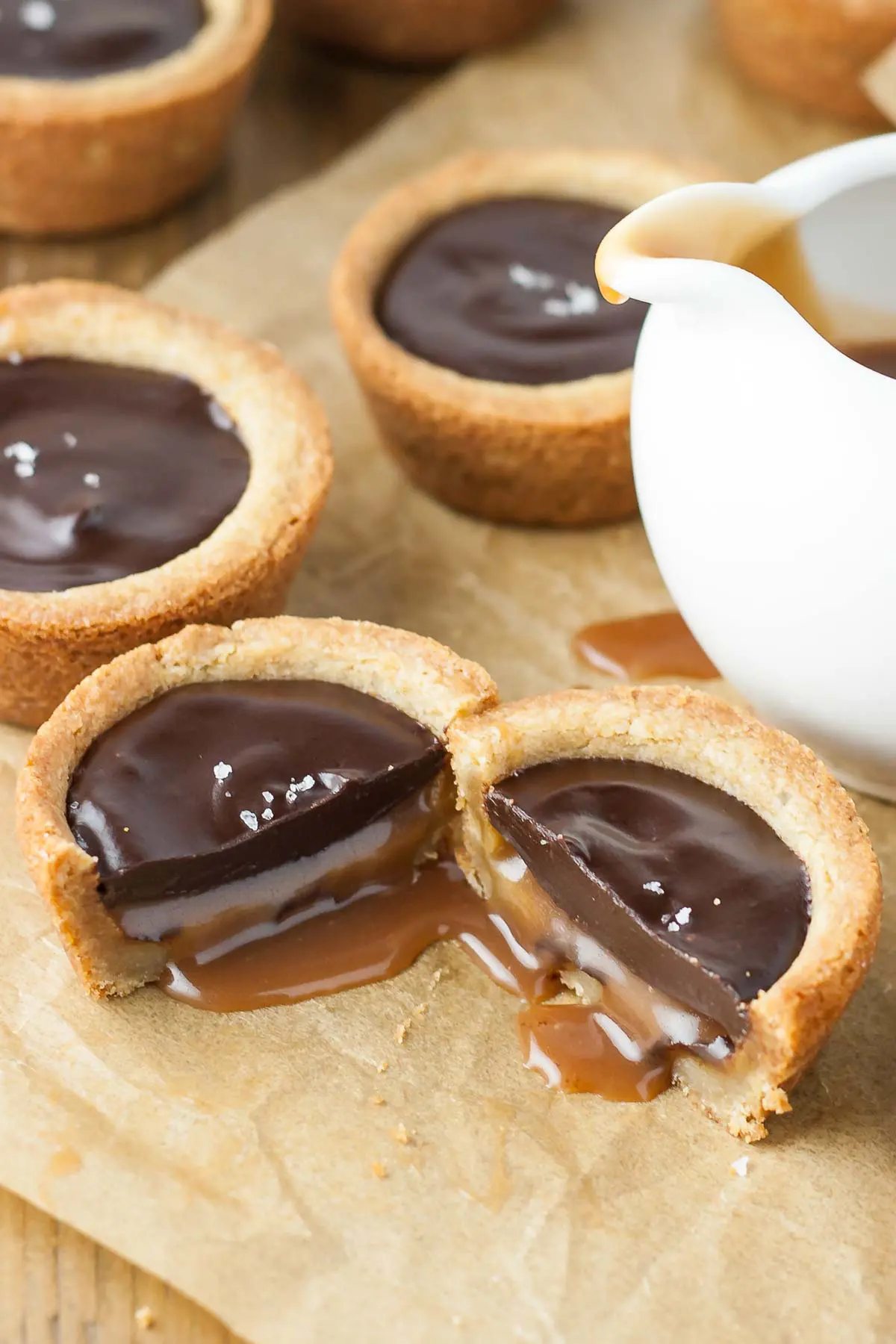 Two cookie cup halves side by side with caramel oozing out.