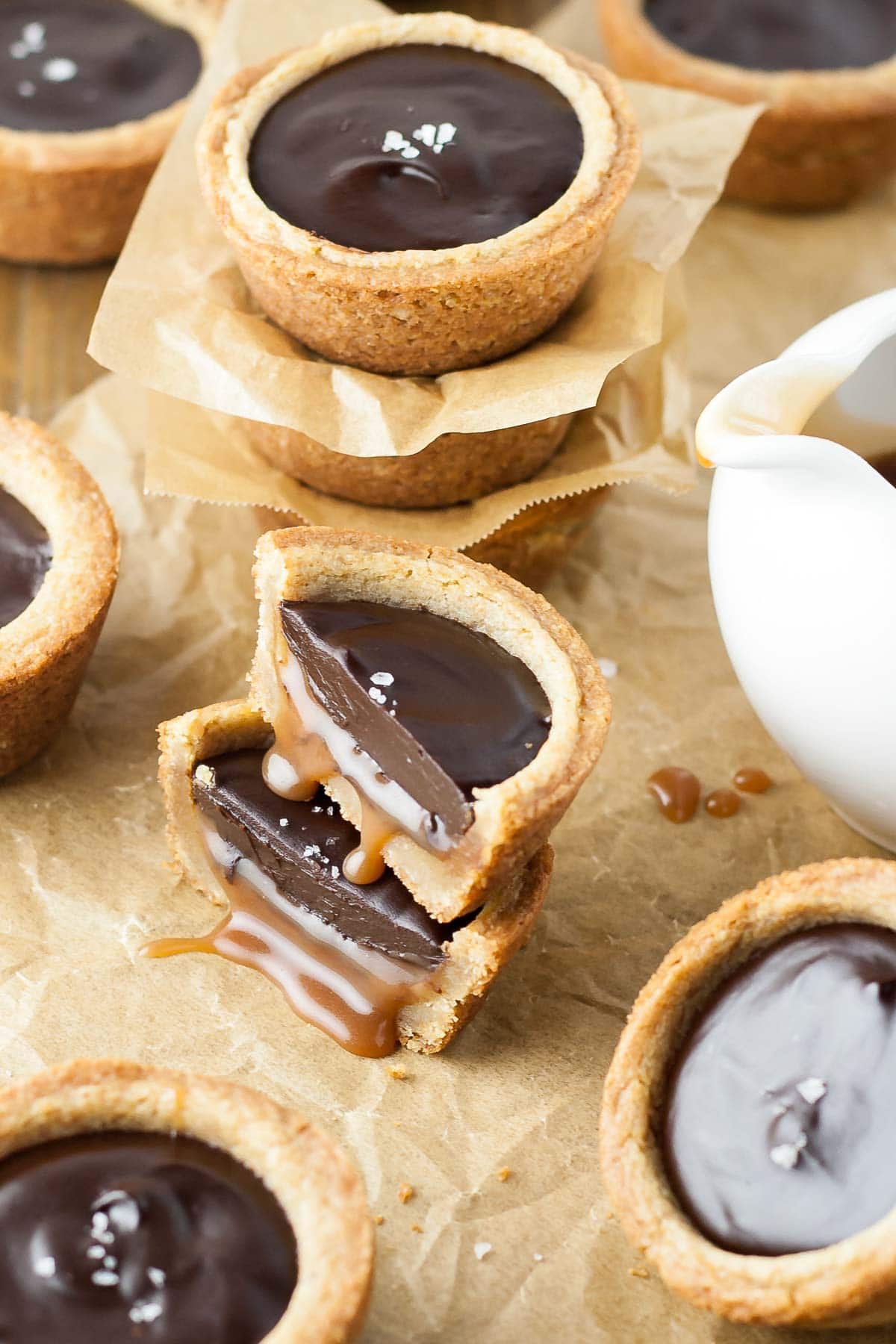 Two cookie cup halves stacked on top of each other with caramel oozing out.