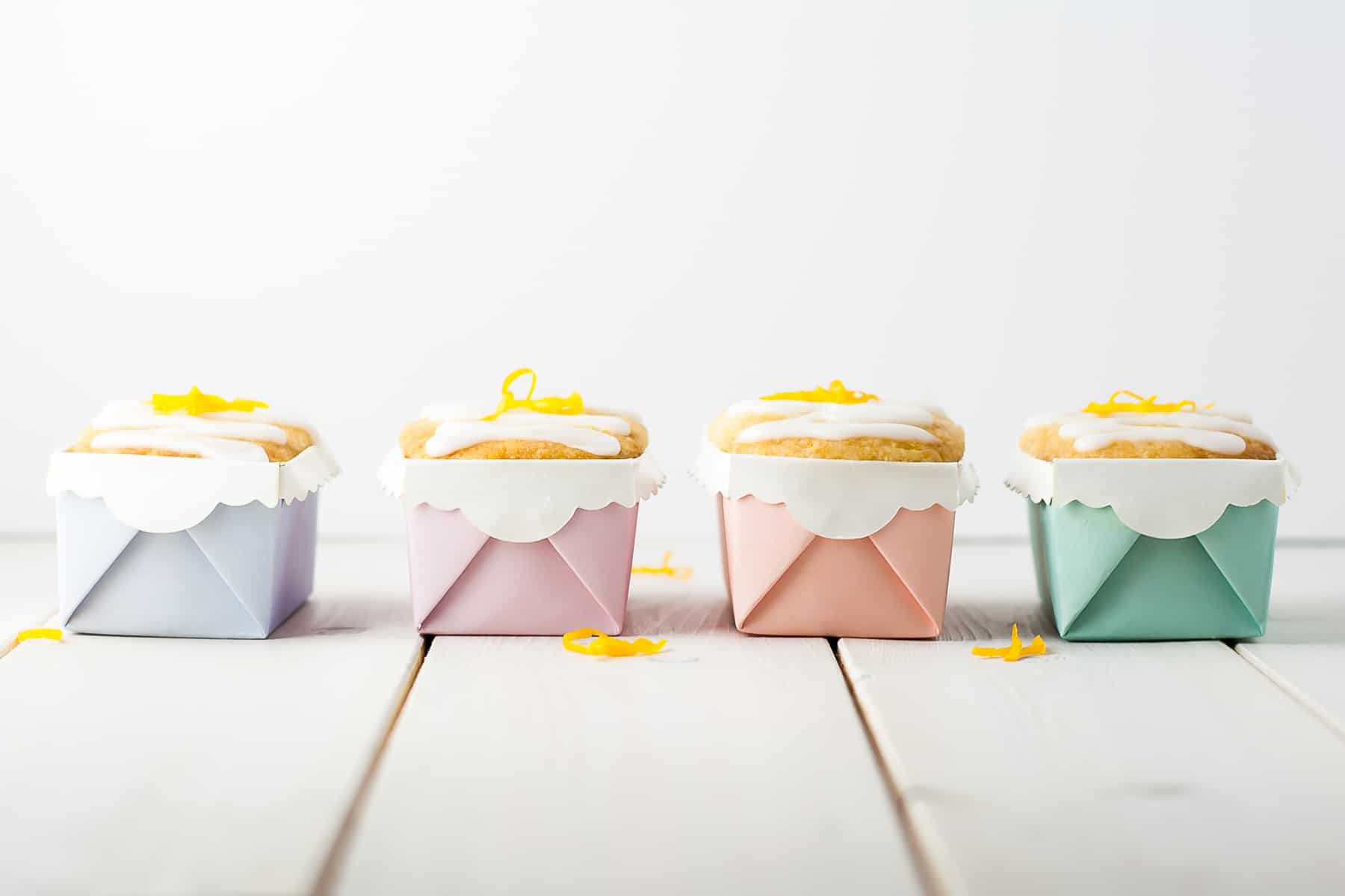 Four mini lemon loaves in pastel liners.