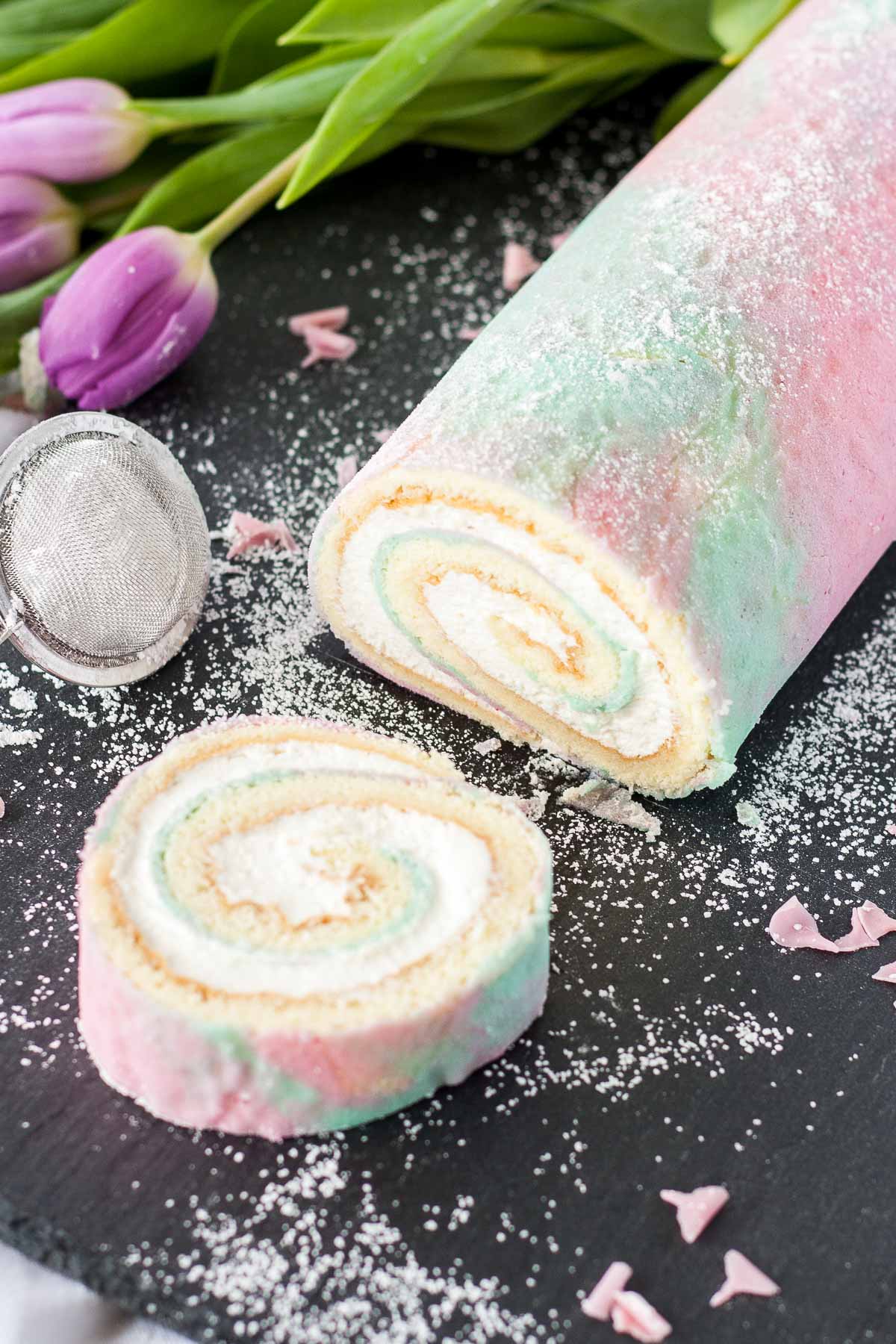 Watercolor cake roll with a slice cut out.