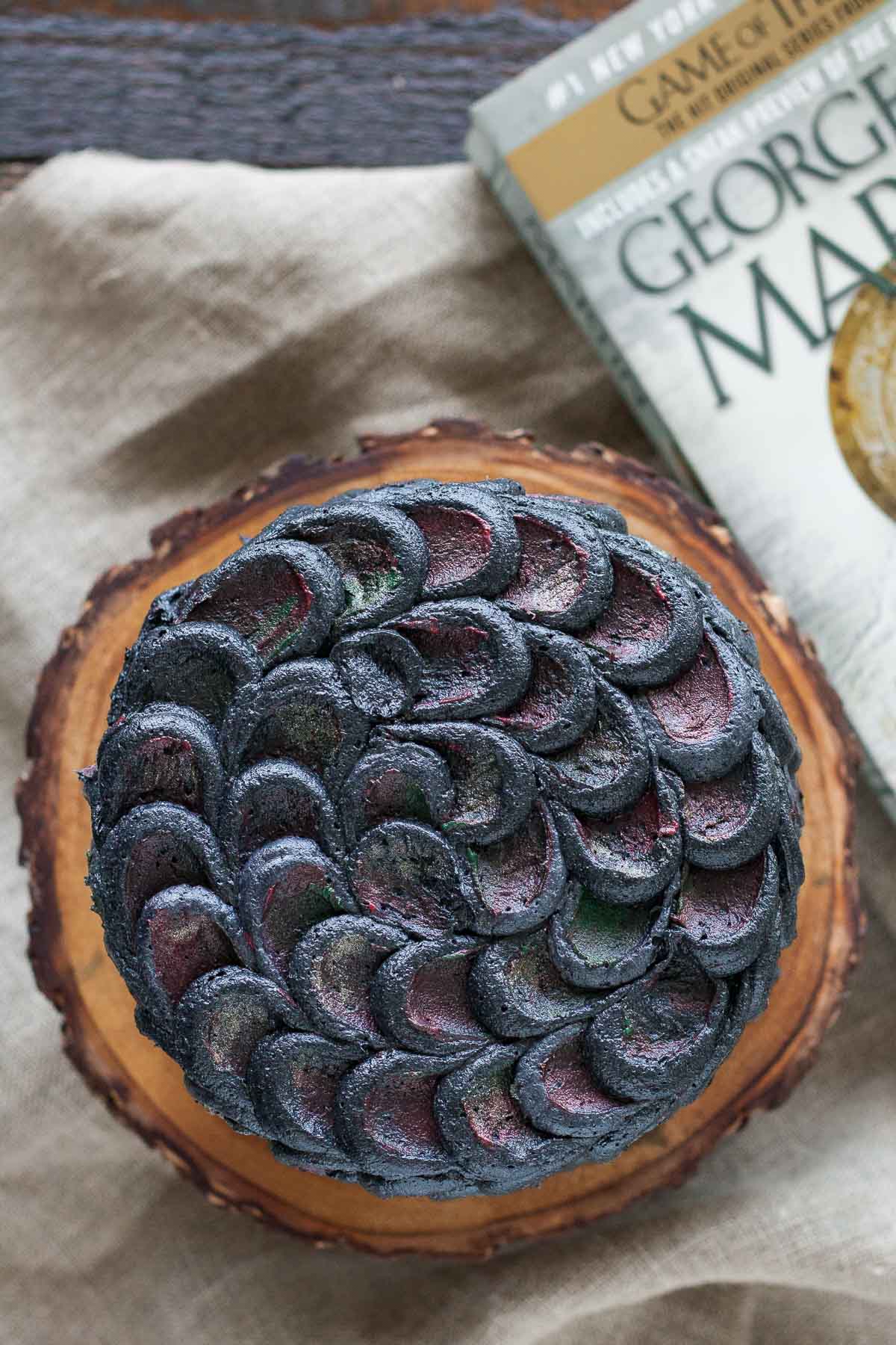 Overhead shot of the cake with a  game of thrones book beside it.