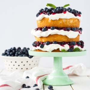 Blueberry shortcake cake sitting on a green cake stand.
