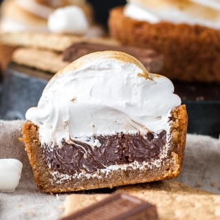 No campfire needed for these S'mores Cookie Cups! Graham cracker cookie cups filled with a Hershey's milk chocolate ganache, topped with toasted homemade marshmallow fluff. | livforcake.com