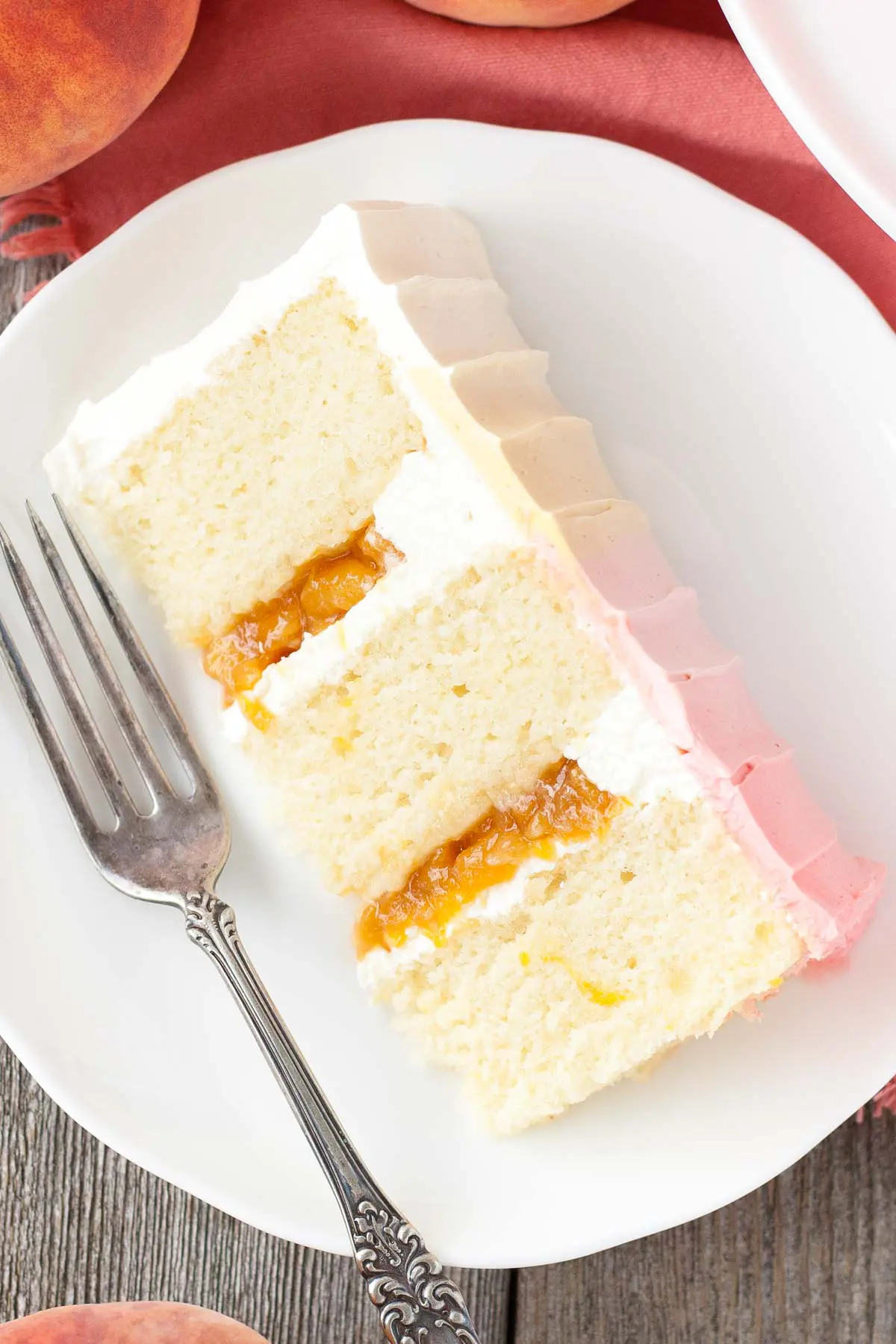 Another picture of a cake slice on a plate showing the homemade peach filling.