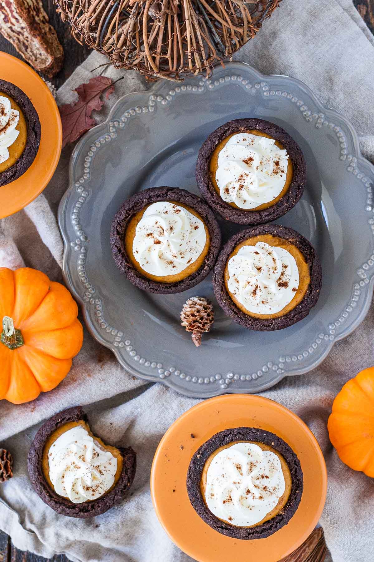 Overhead shot of cookie cups on a grey plate with fall decor around them.