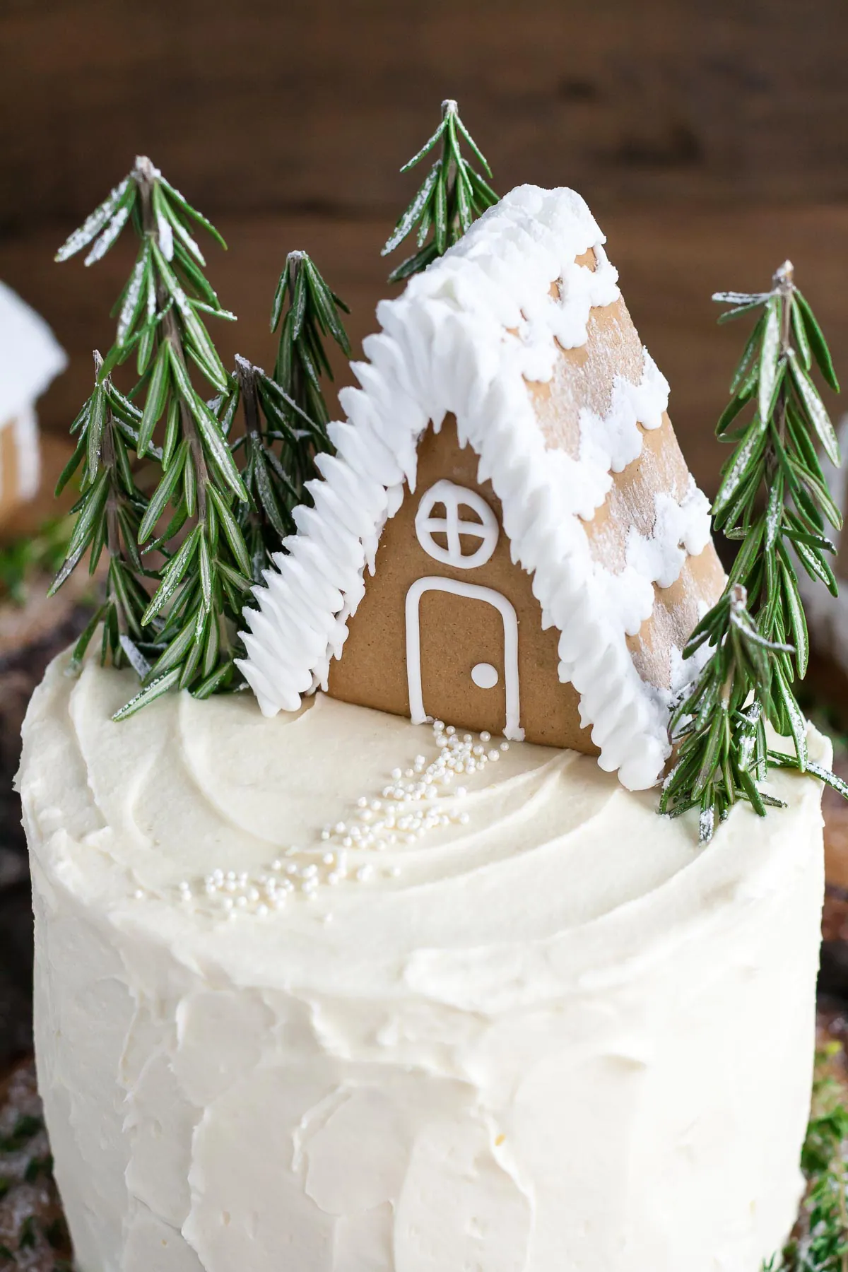 Close up of gingerbread house on top of a cake