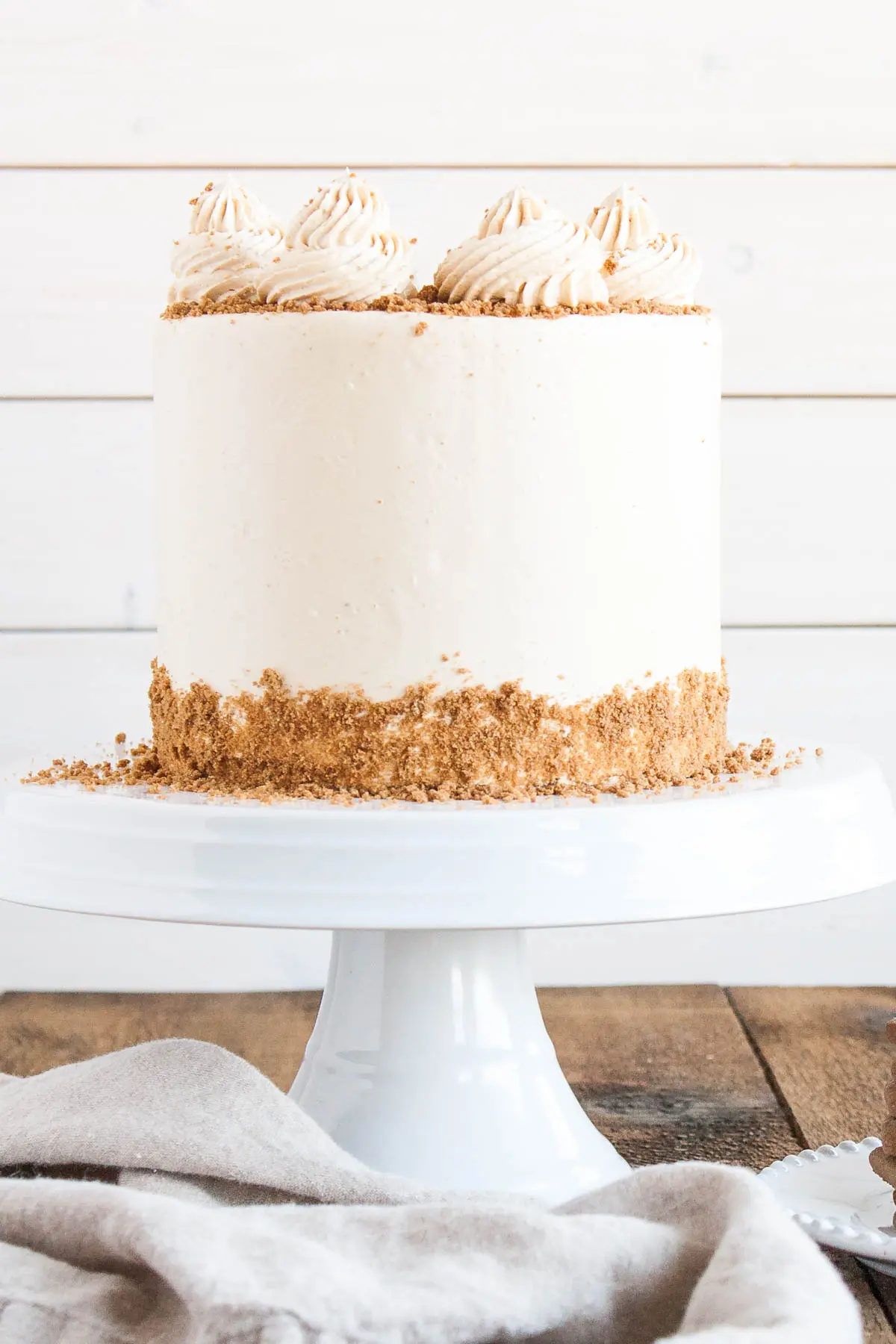 Straight on shot of the cake on a white cake stand and a white background.