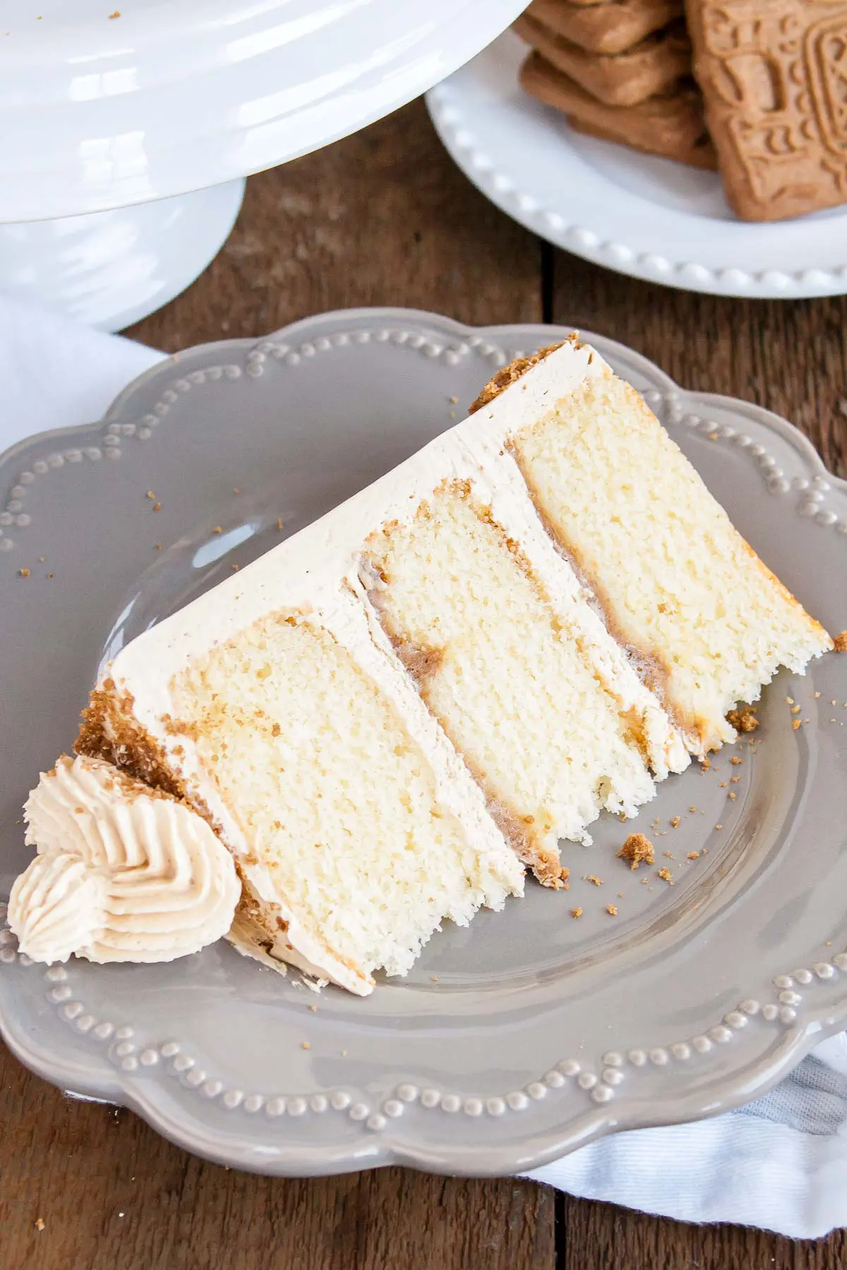 Slice of biscoff cake on a plate showing the layers of crunchy cookie butter.