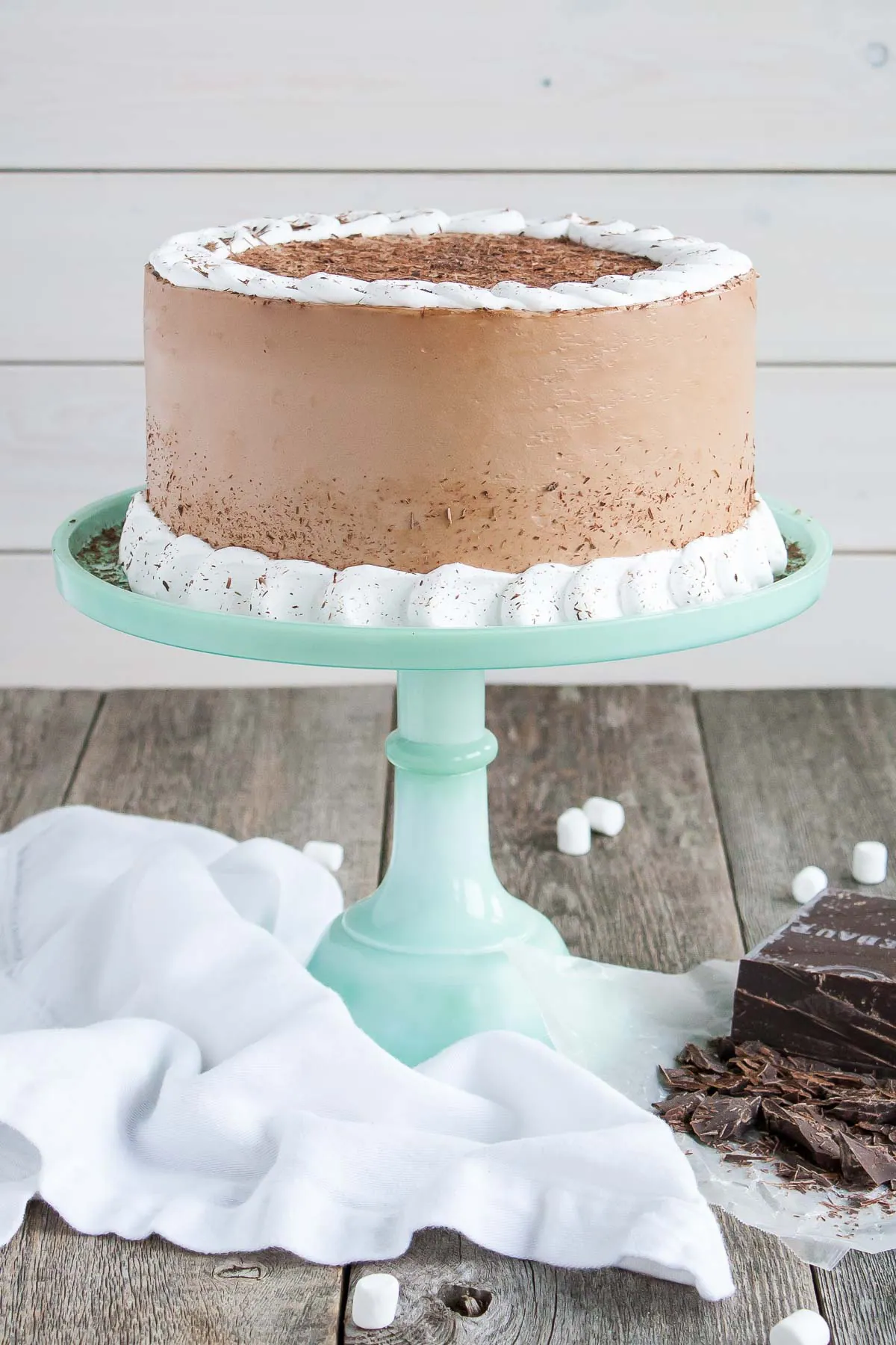 Cake on a cake stand on a wooden table.