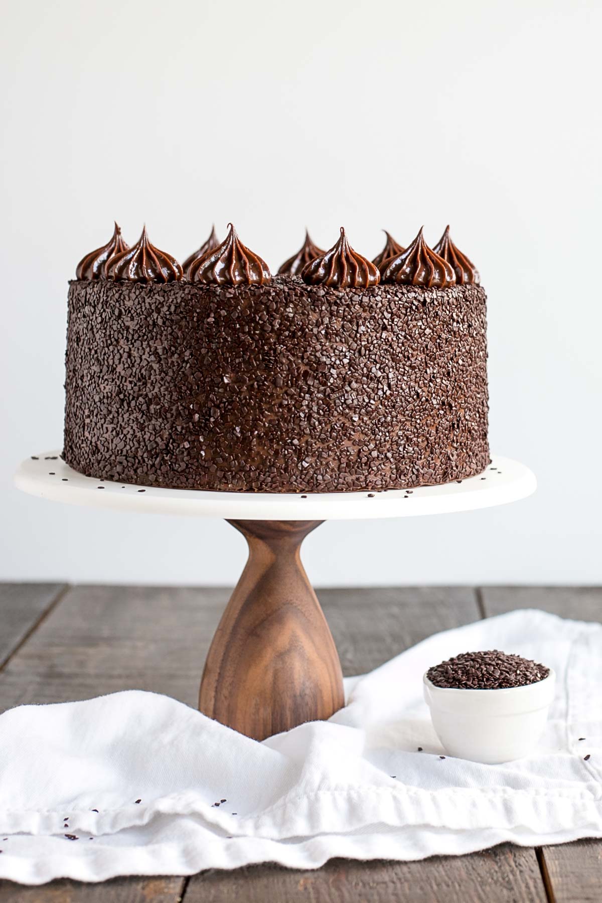 Chocolate cake on a white cake stand.