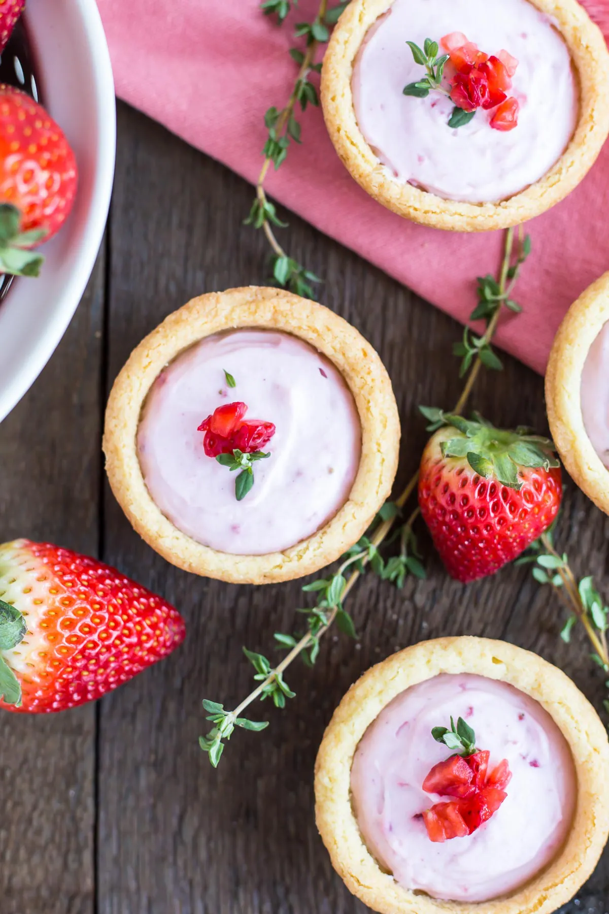 Cookie cups with fruit on top of a wooden table