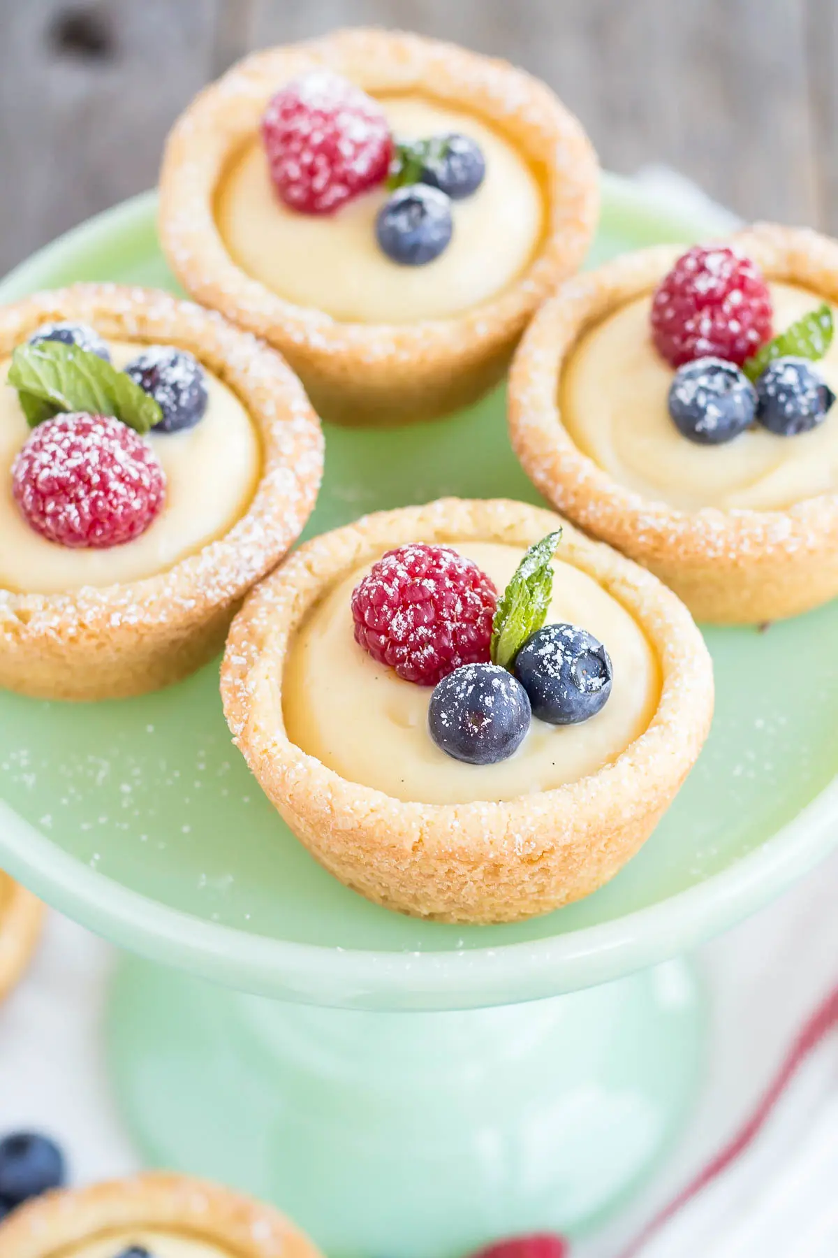 A close up the cookie cups on a mint green cake stand.