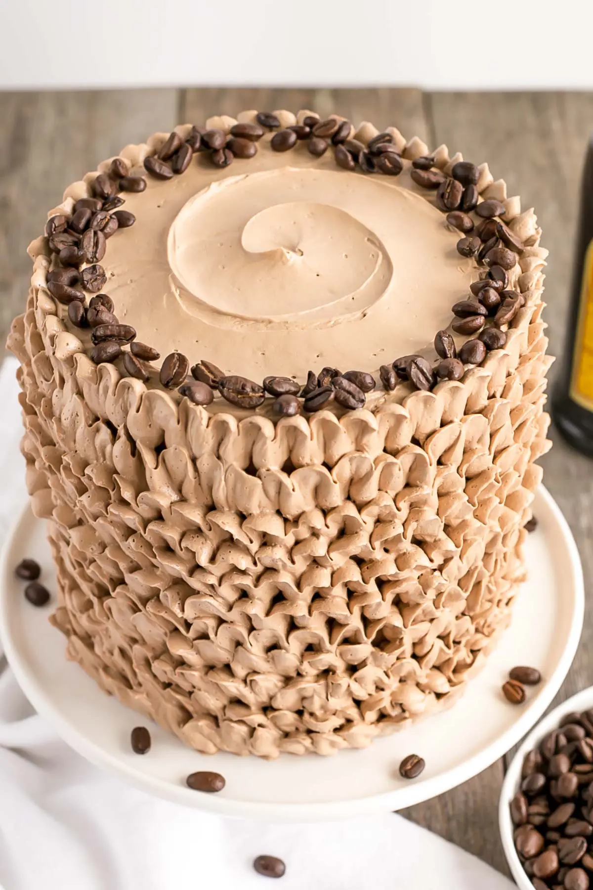 Top view of the cake with a frosting swirl on top and coffee beans