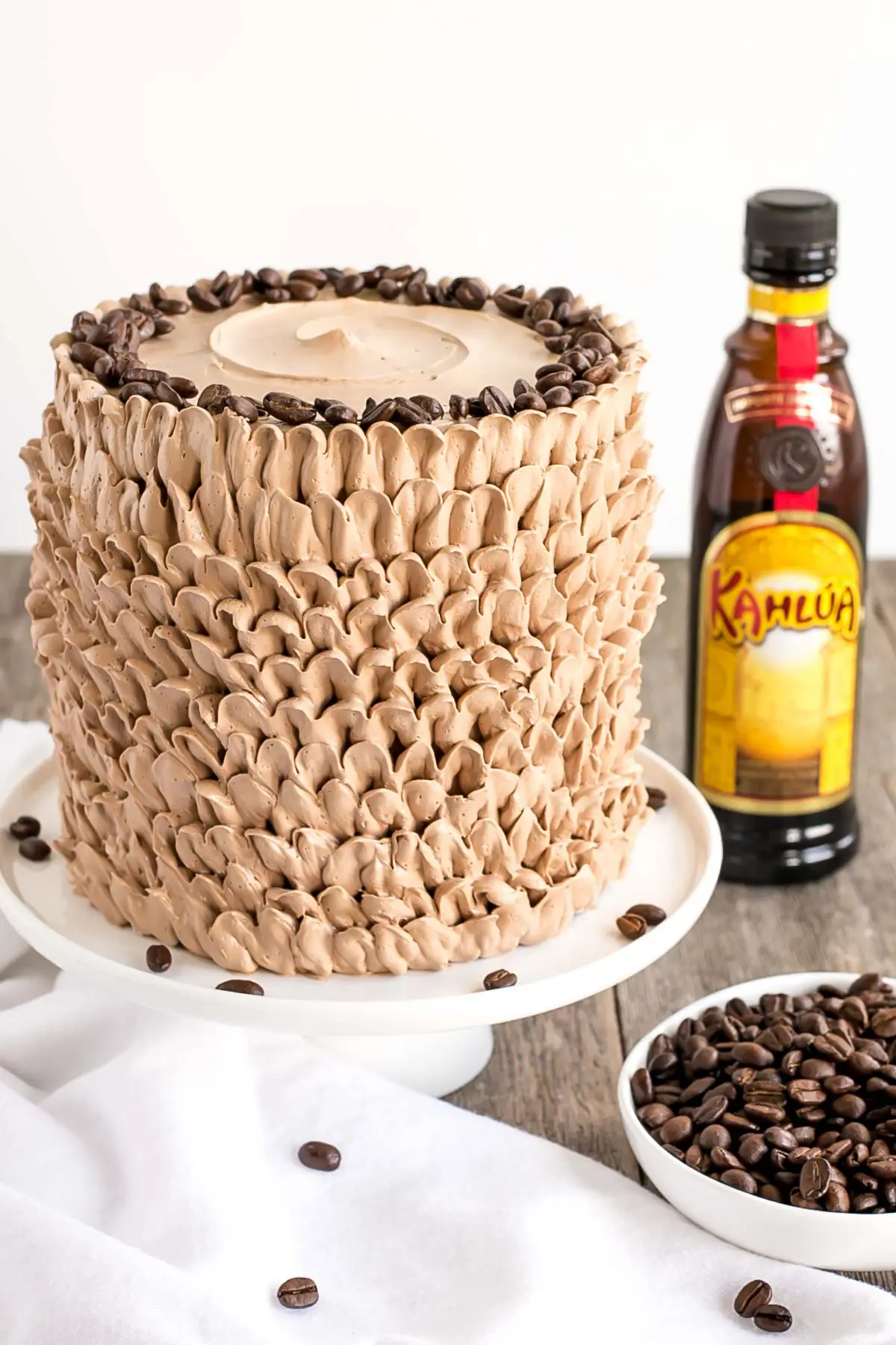 Kahlua cake with buttercream ruffles and coffee beans on top.