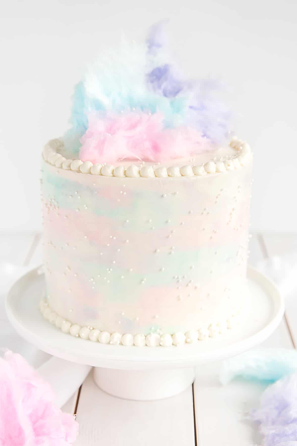 Cotton Candy Cake with watercolor frosting and cotton candy on top.