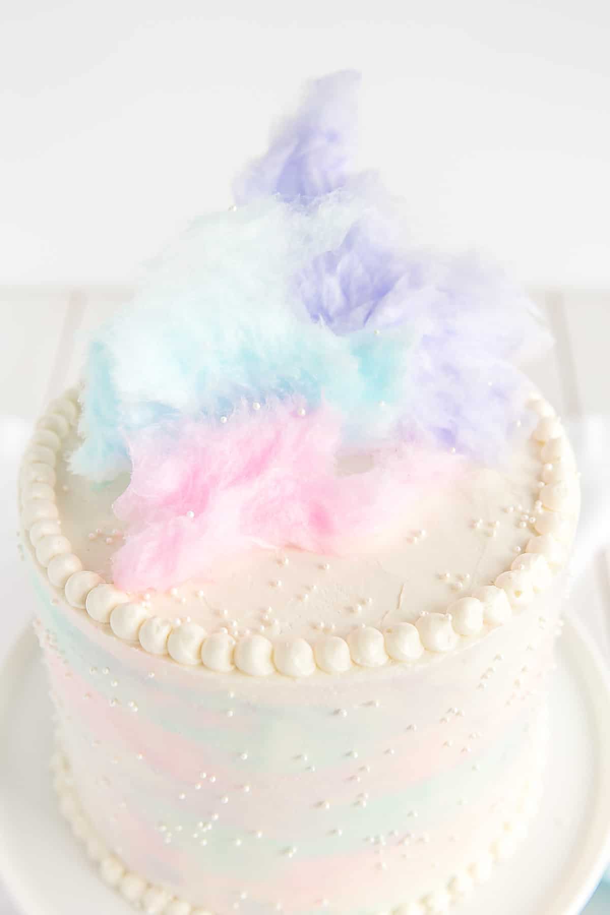 The top of this Cotton Candy Cake decorated with cotton candy and white sprinkles.