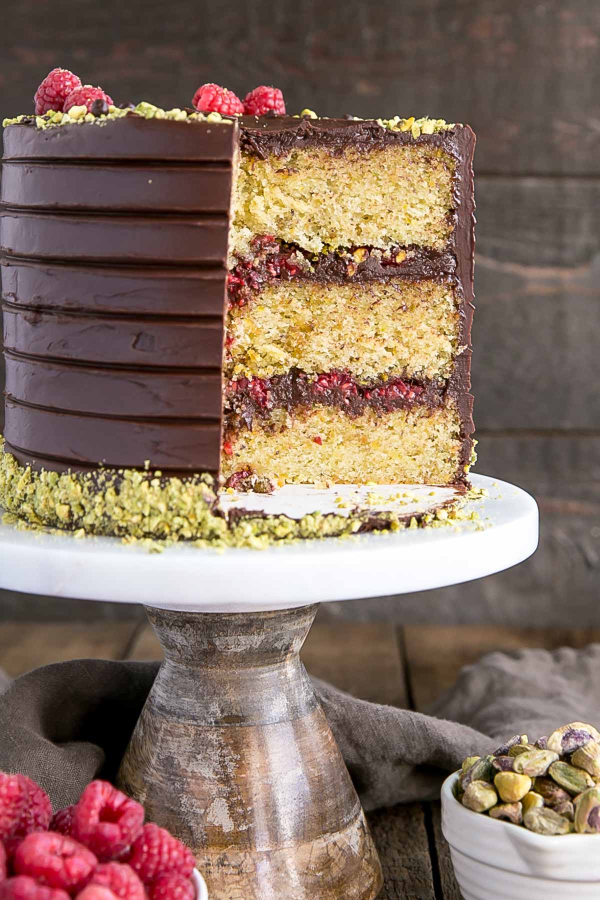 Pistachio cake layers with dark chocolate ganache and fresh raspberries.