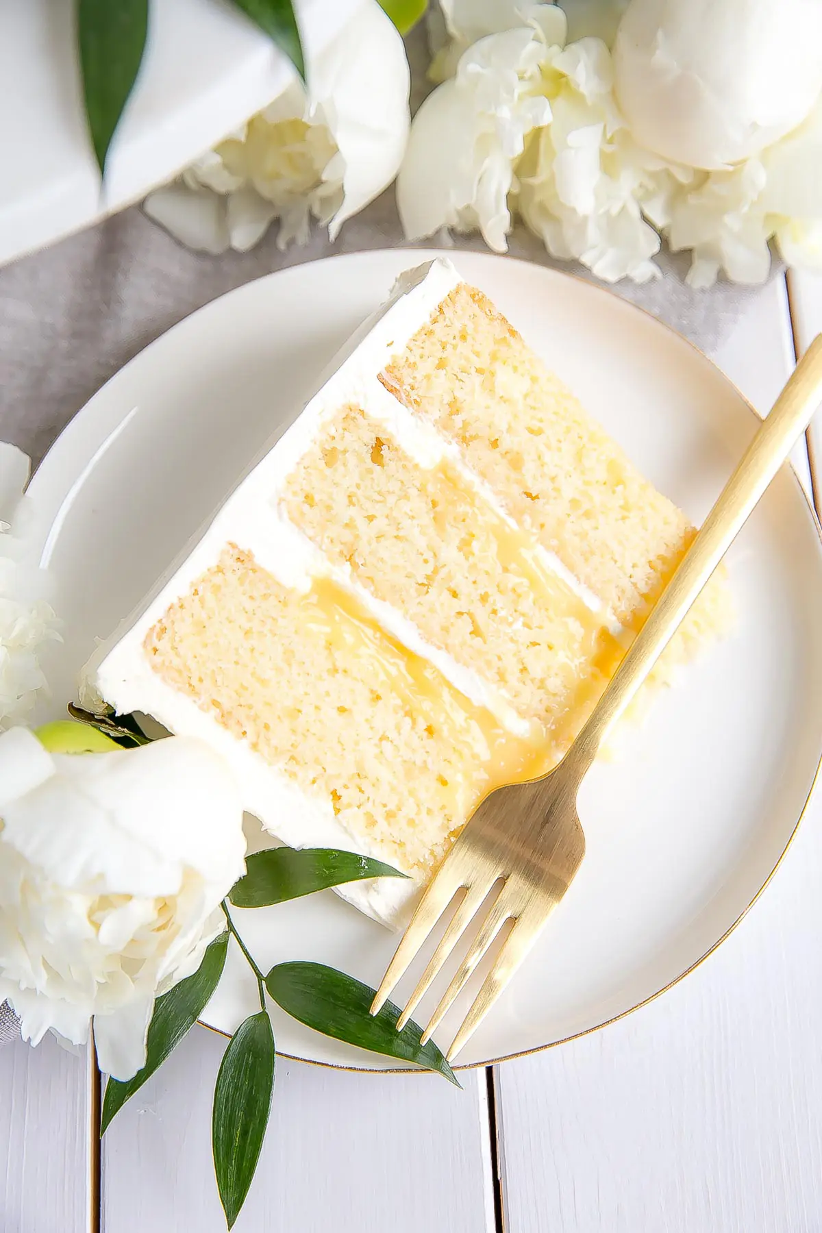 Slice of Lemon Elderflower Cake, copycat royal wedding cake! Elderflower infused lemon cake layers with lemon curd and elderflower buttercream.