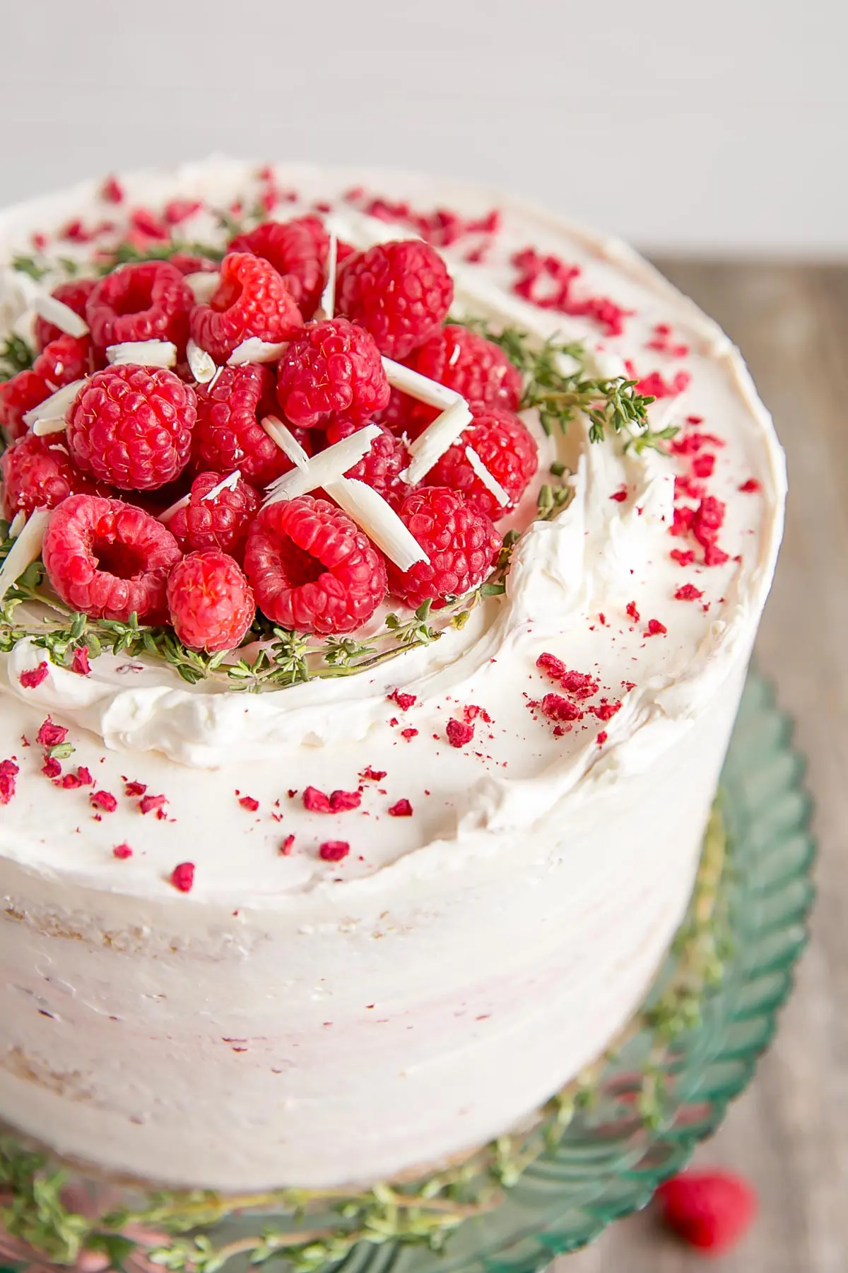 Close up of fresh raspberries on top of a white chocolate cake