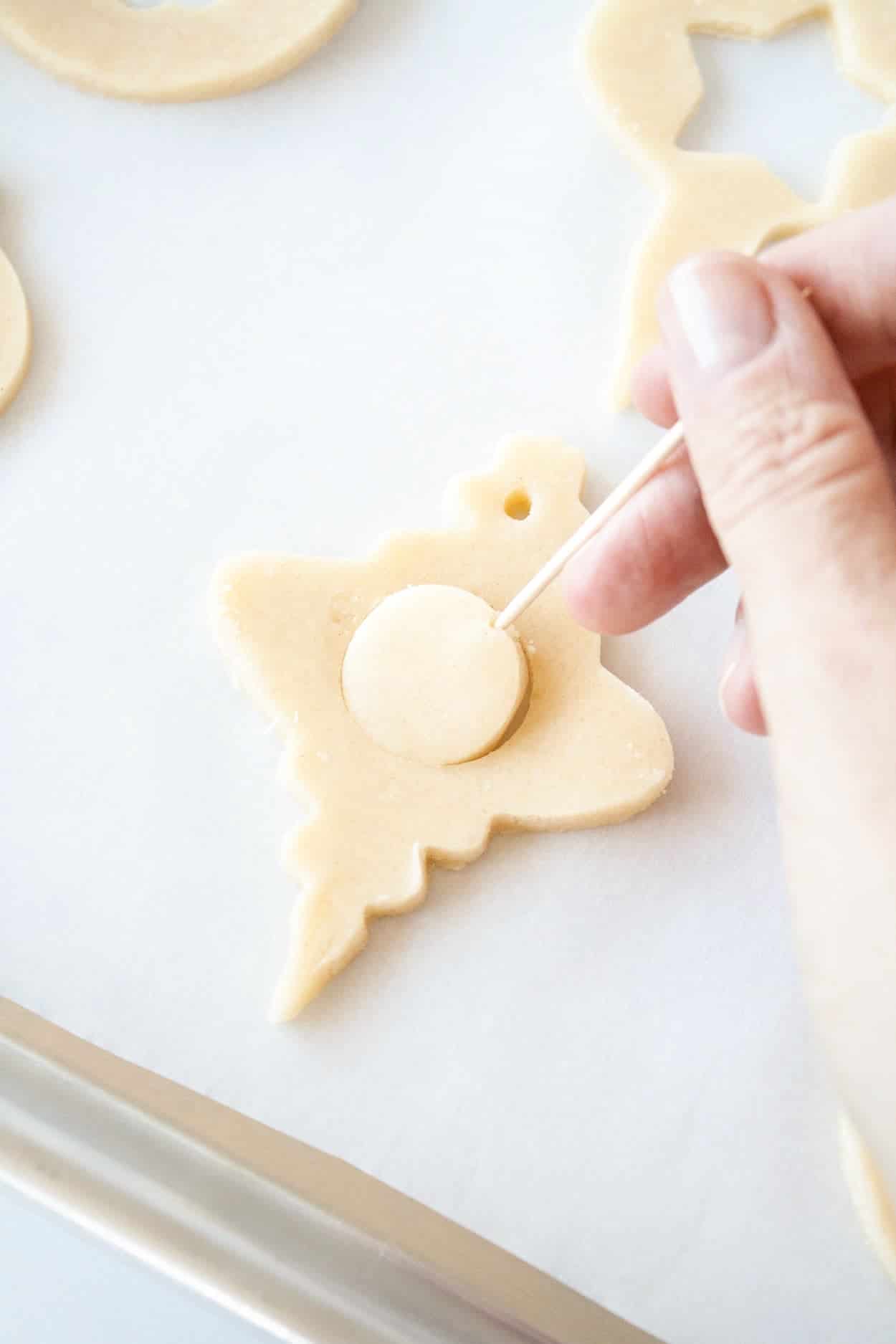 A cookie with the cut out being removed.