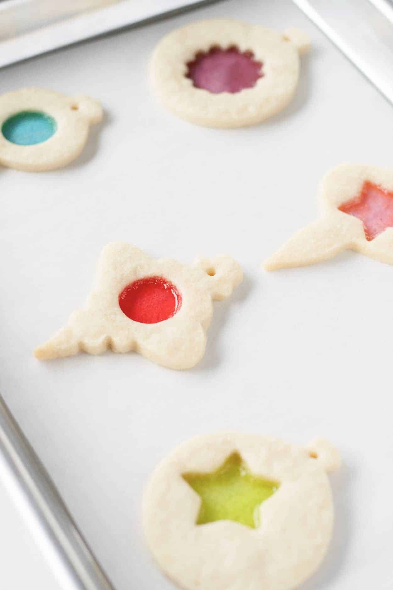 Baked stained glass cookies on a baking sheet.