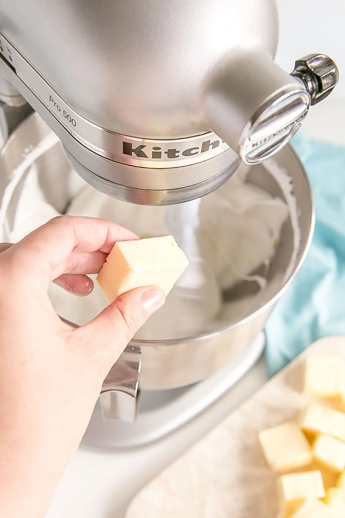 Adding butter while meringue continues to whip.