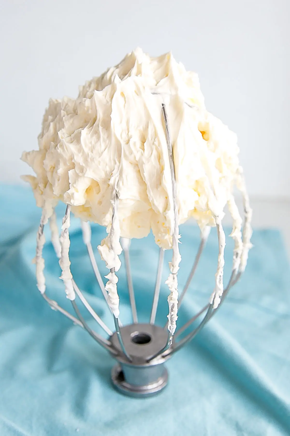Swiss meringue buttercream on a stand mixer whisk.