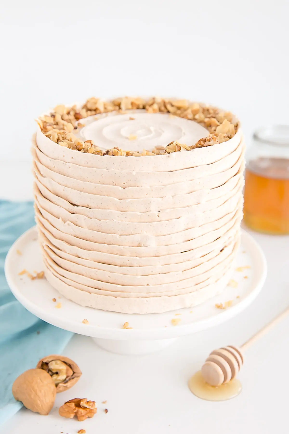 Baklava cake with layers of honey cinnamon frosting and sprinkled with chopped walnuts and baked filo.