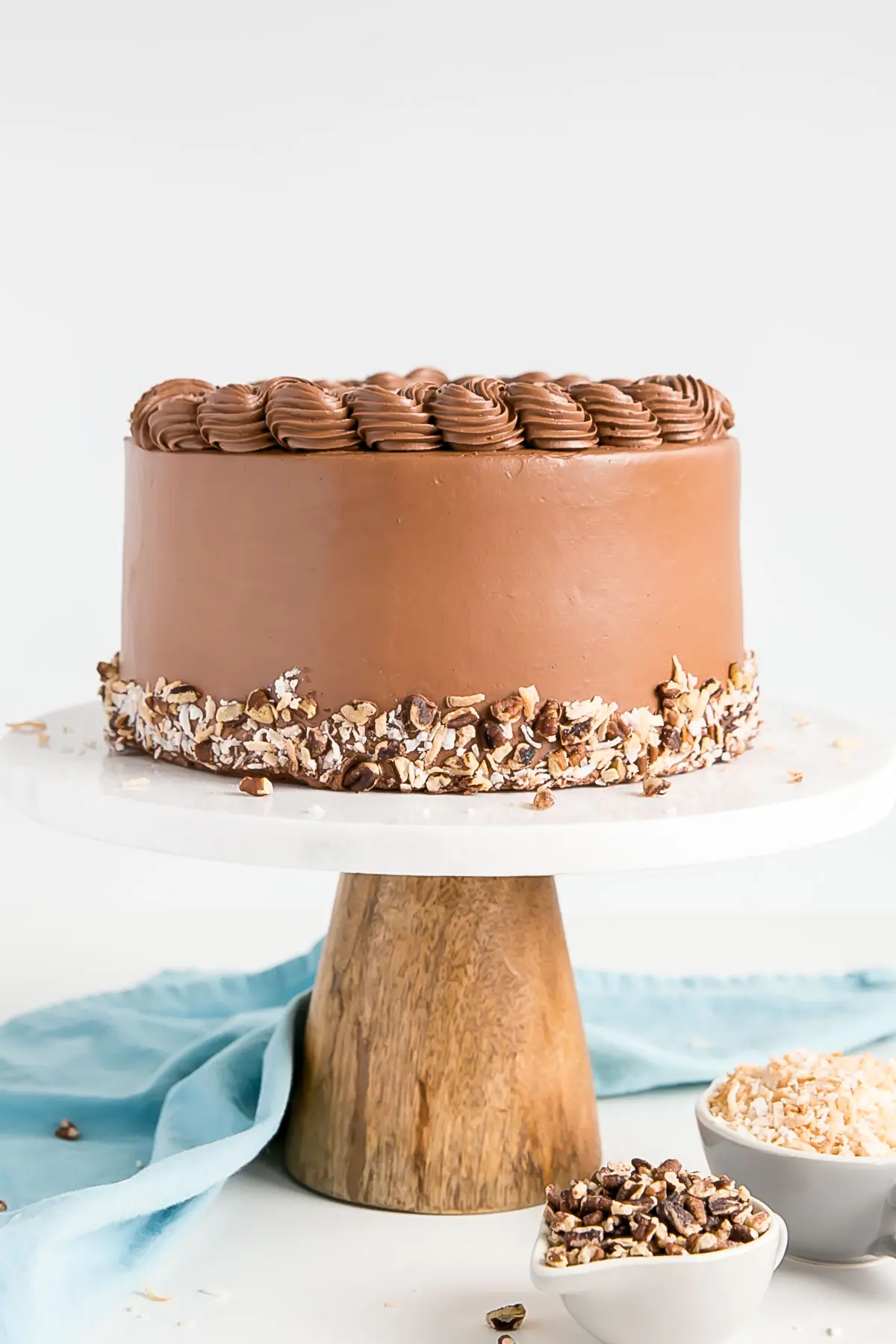 Straight on shot of the cake on a marble and wood cake stand.