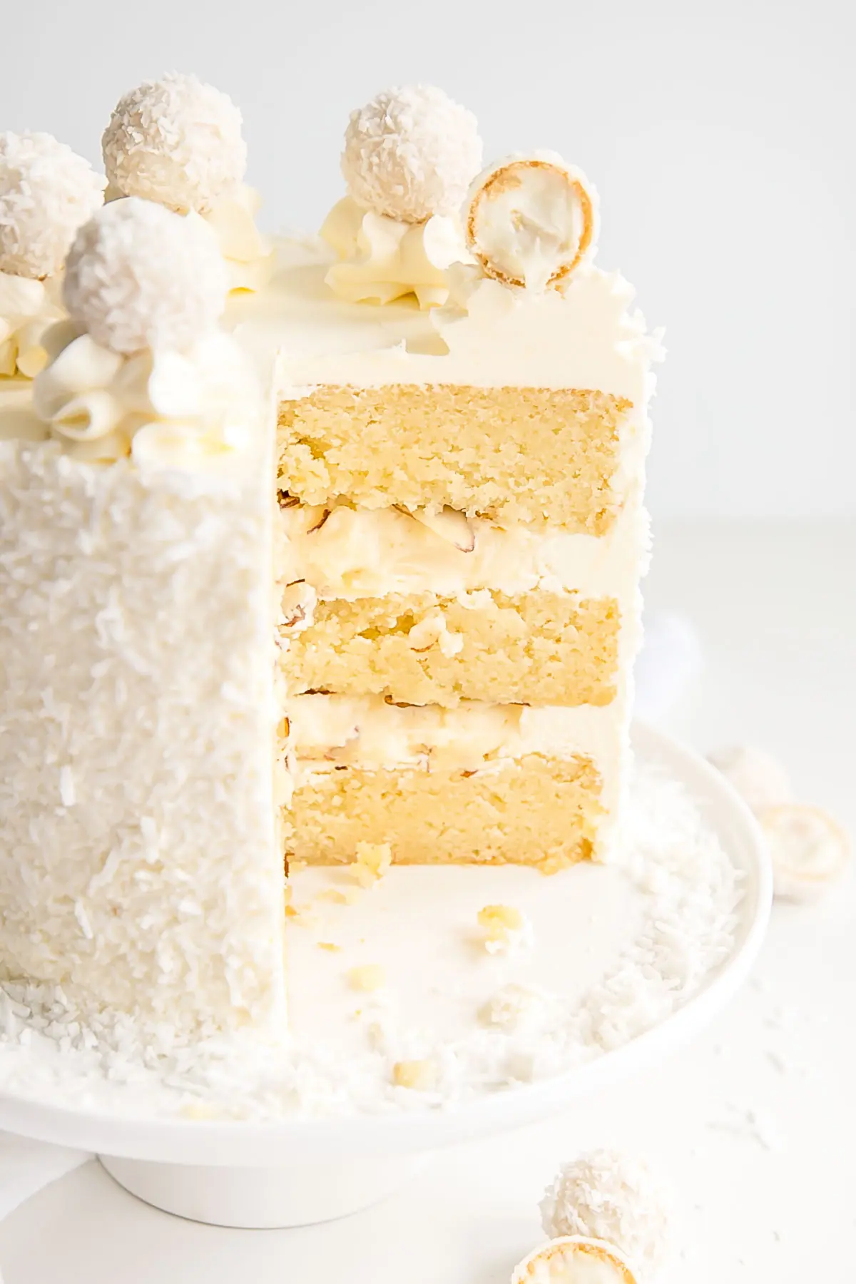 Cross section of a Raffaello Cake with almond cake layers and coconut cream custard.