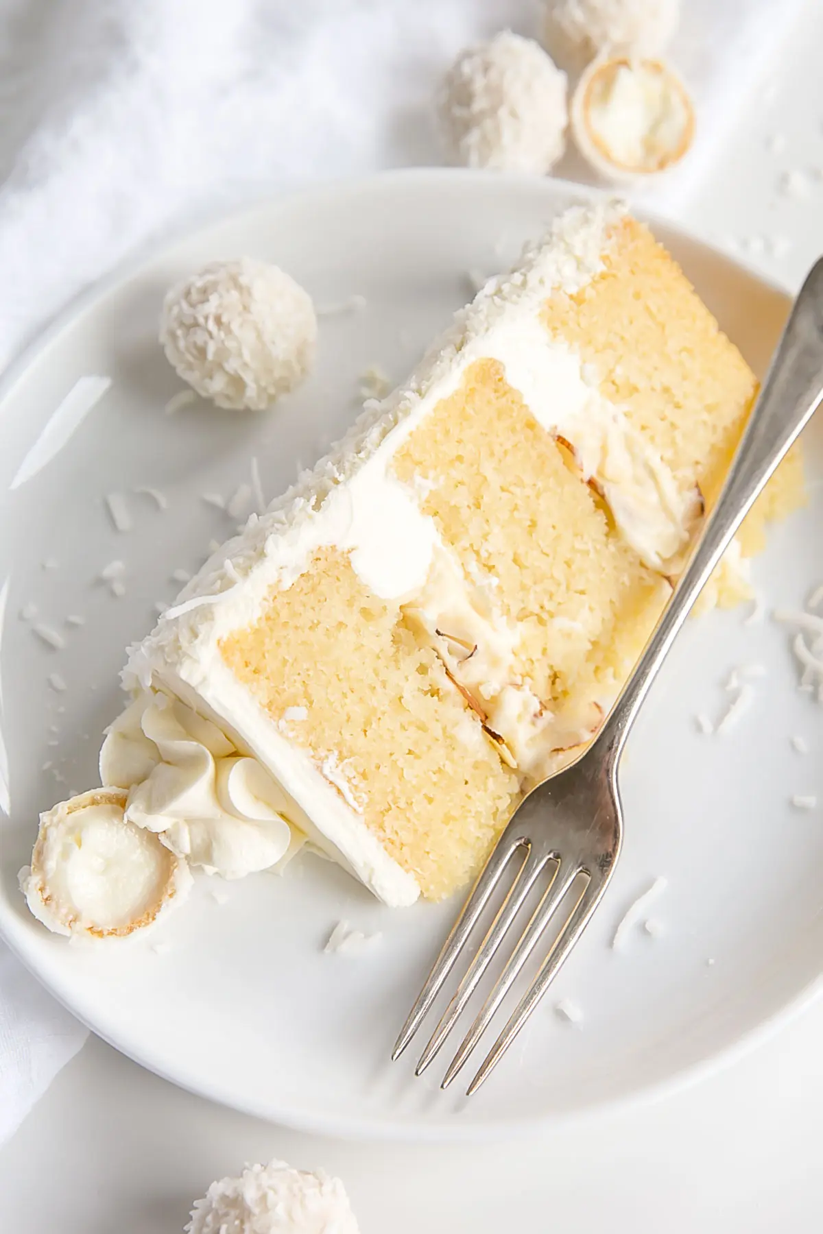 Slice of coconut almond cake on a plate.