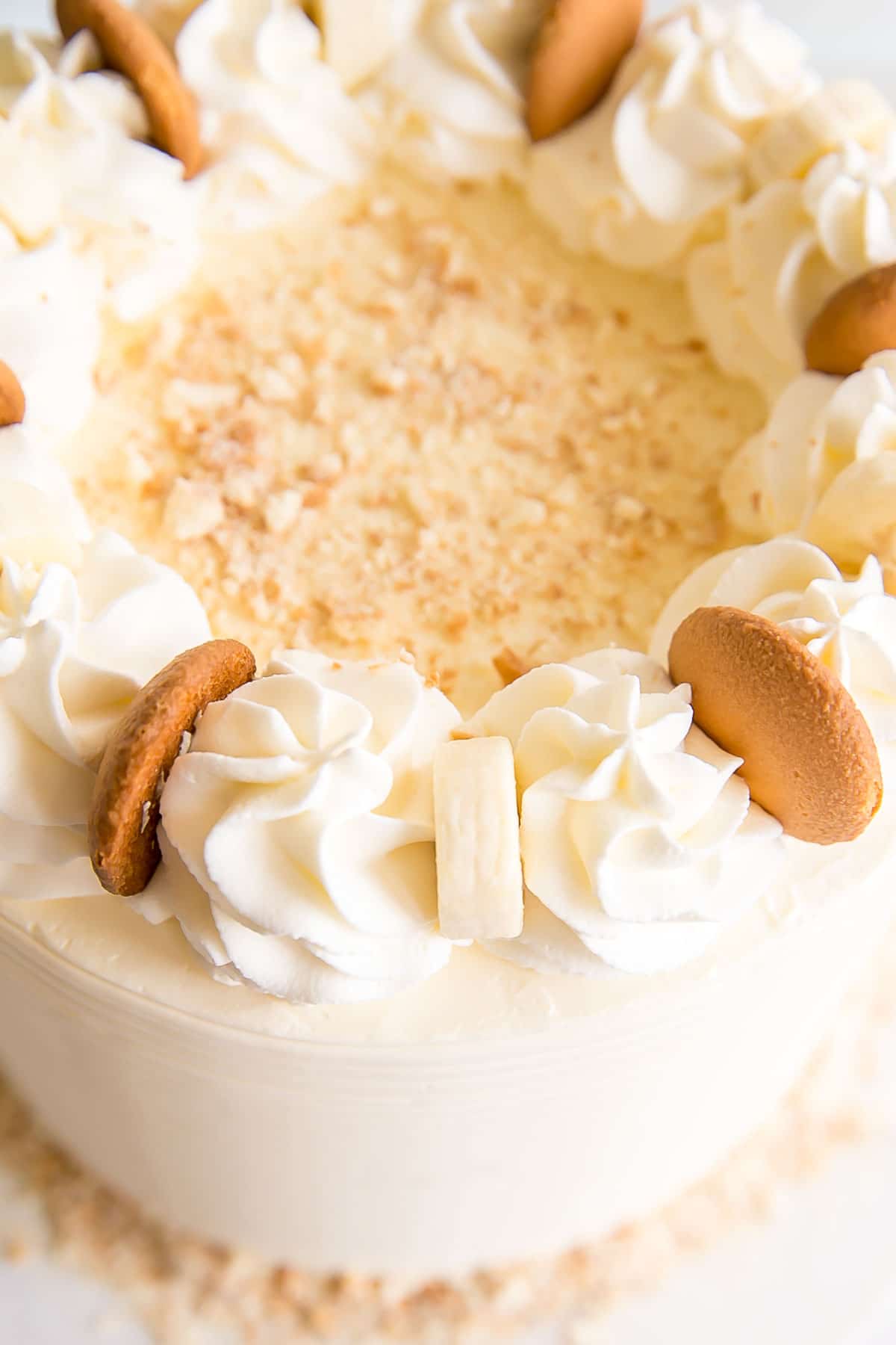 Close up of the top of the cake showing whipped cream rosettes, banana slices, and Nilla wafers.