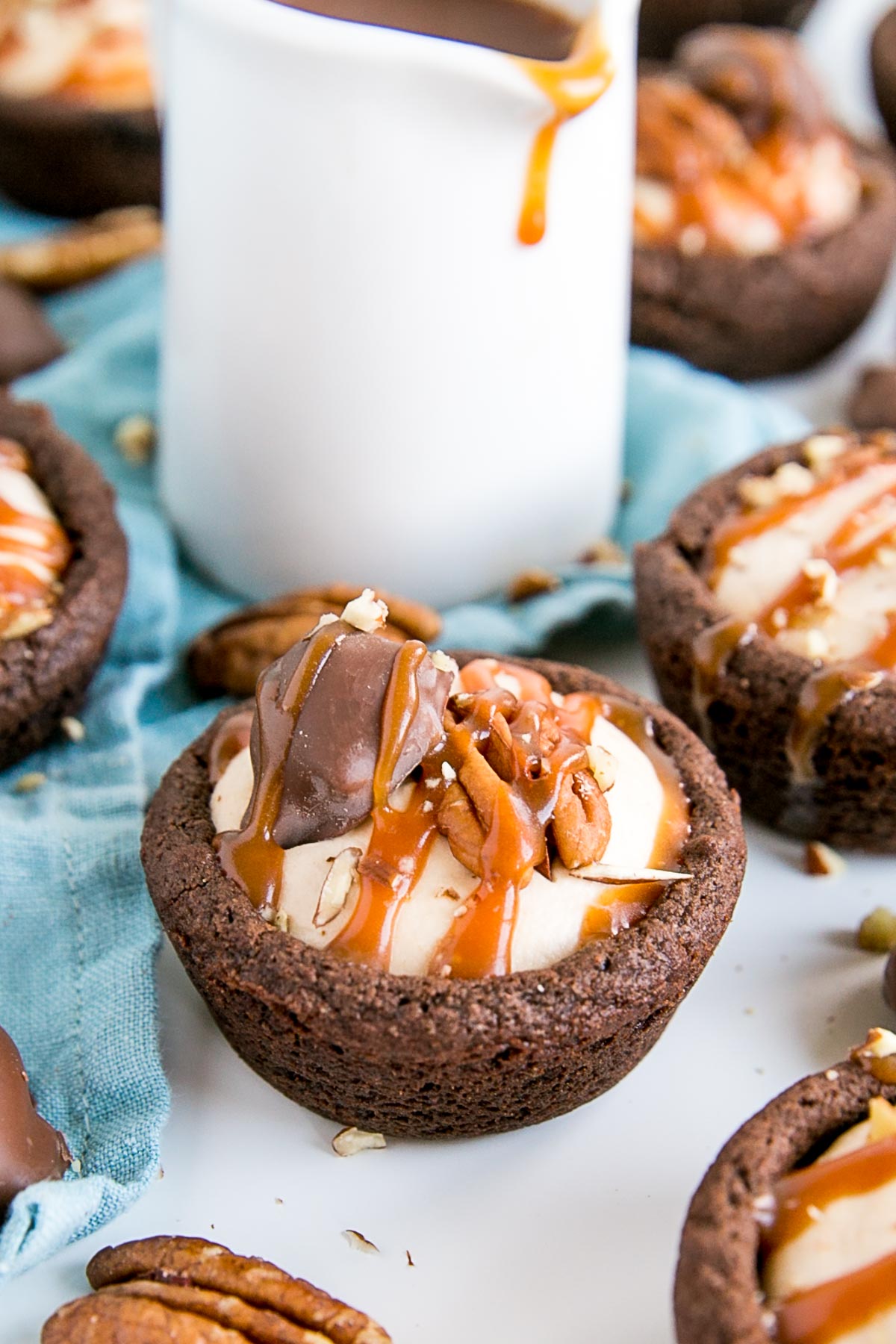 Chocolate cookie cups filled with a caramel whipped cream and drizzled with more caramel.